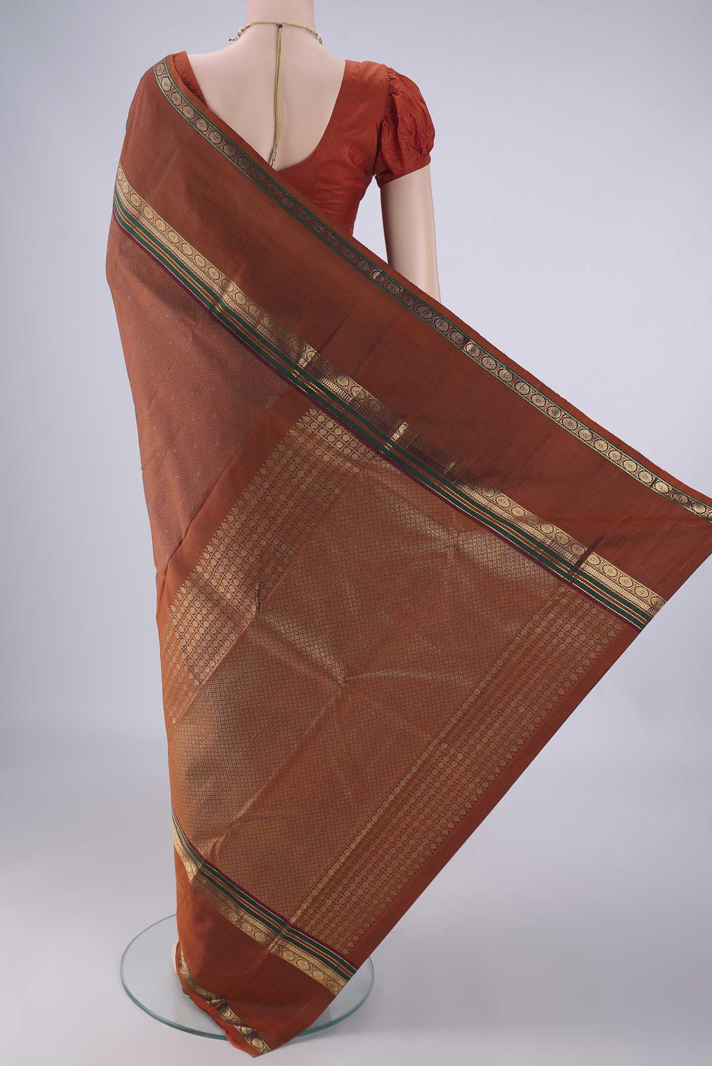 Flat view of Rust Kanchipuram Silk Saree with Jacquard design on the body and Zari Border. 