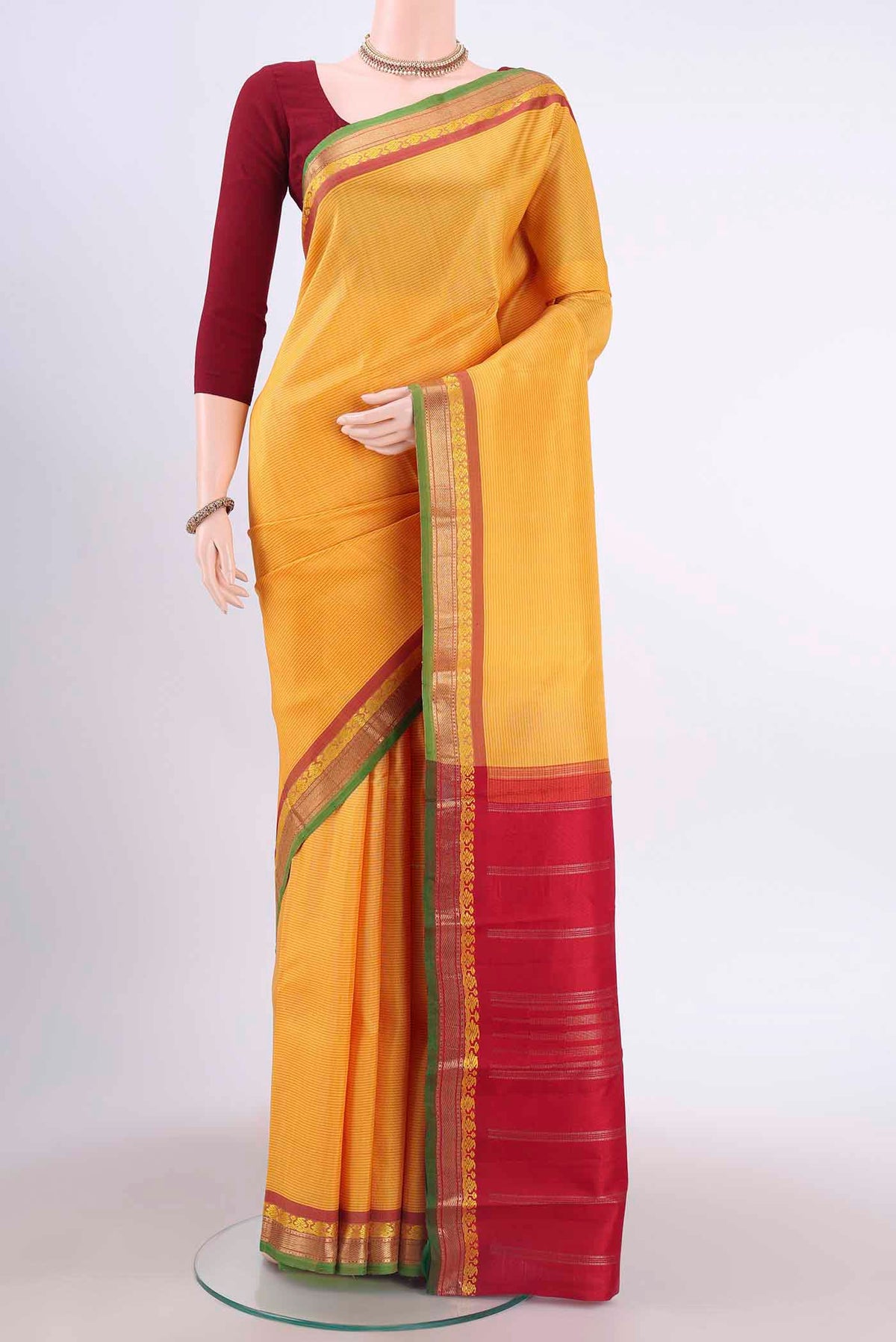 Yellow Kanchipuram Silk Saree with Stripes on the body and Zari And Thread Border displayed on a mannequin