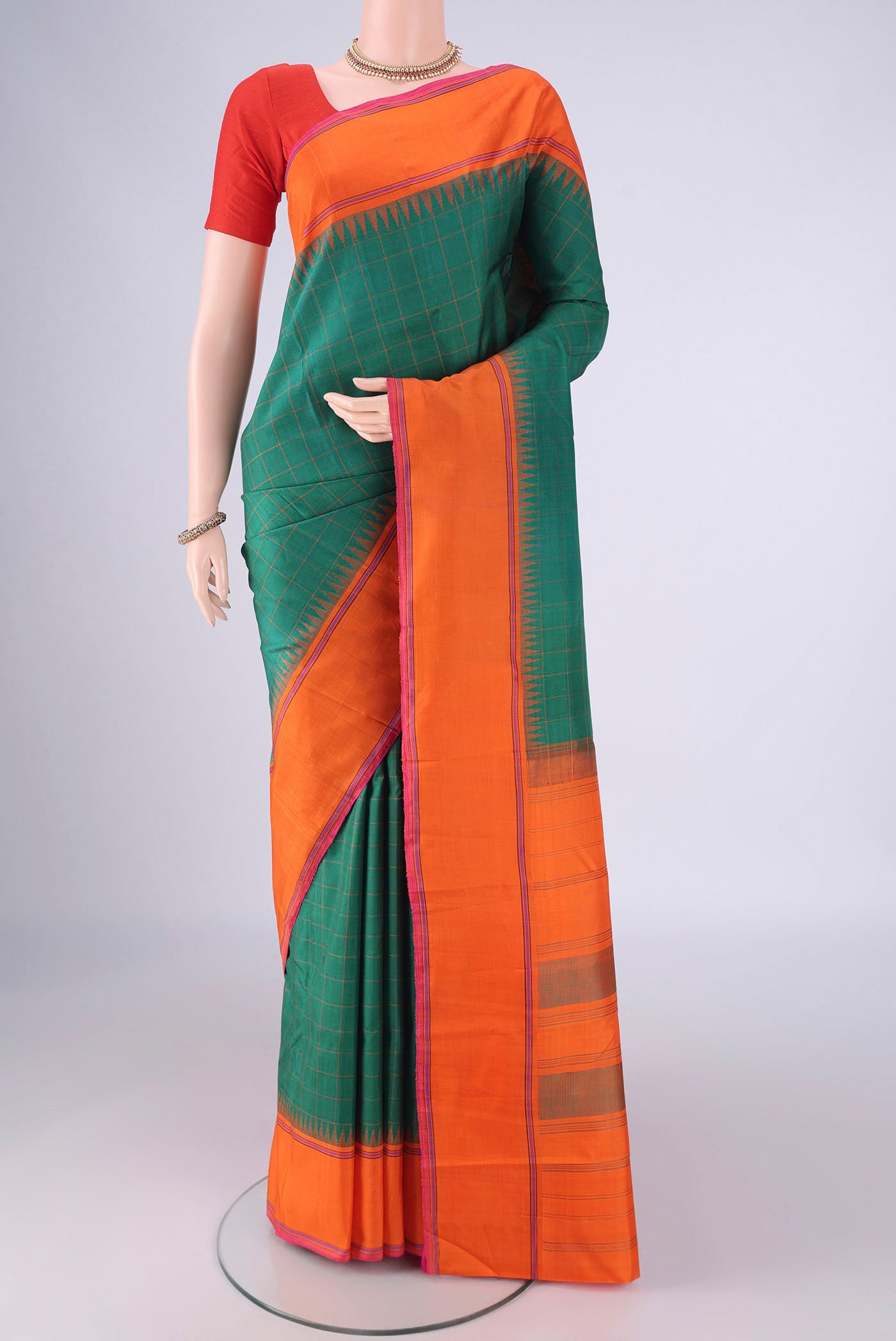 Green Kanchipuram Silk Saree with Checked design on the body and Temple Thread Border.  displayed on a mannequin