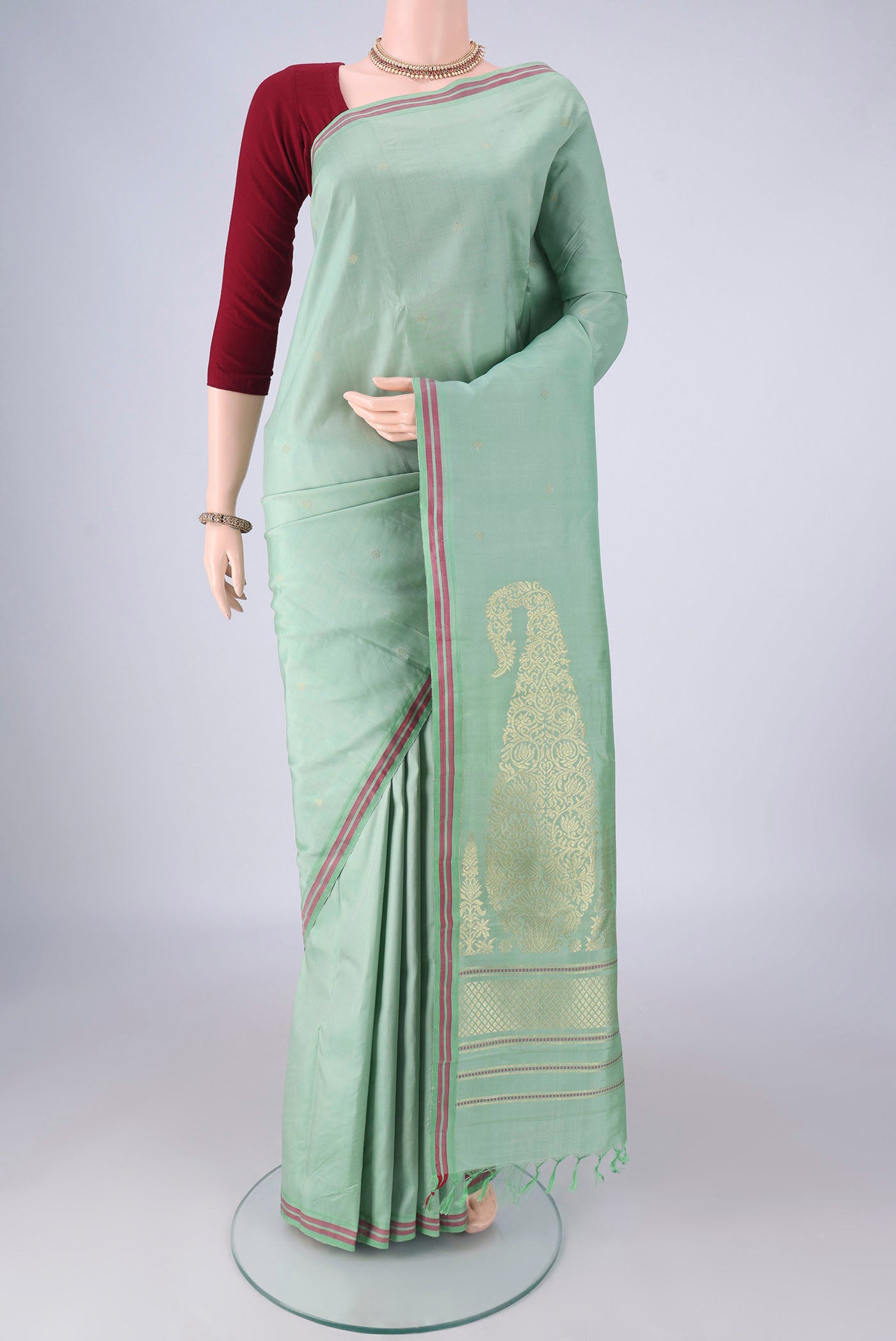 Sea Green Kanchipuram Silk Saree with Zari Butta on the body and Plain Border.  displayed on a mannequin