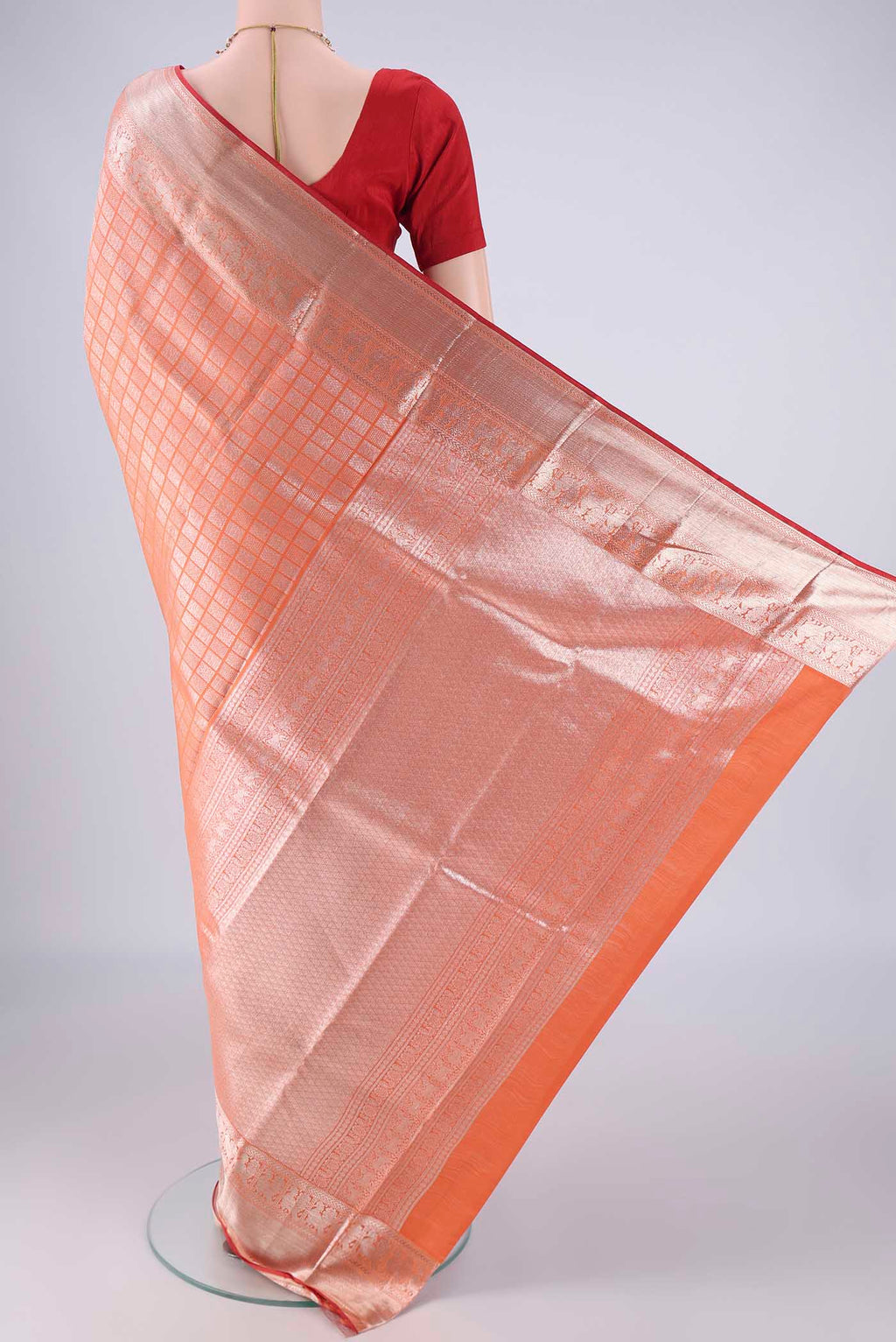Flat view of Orange Kanchipuram Silk Saree with Zari Brocade on the body and Zari Border. 