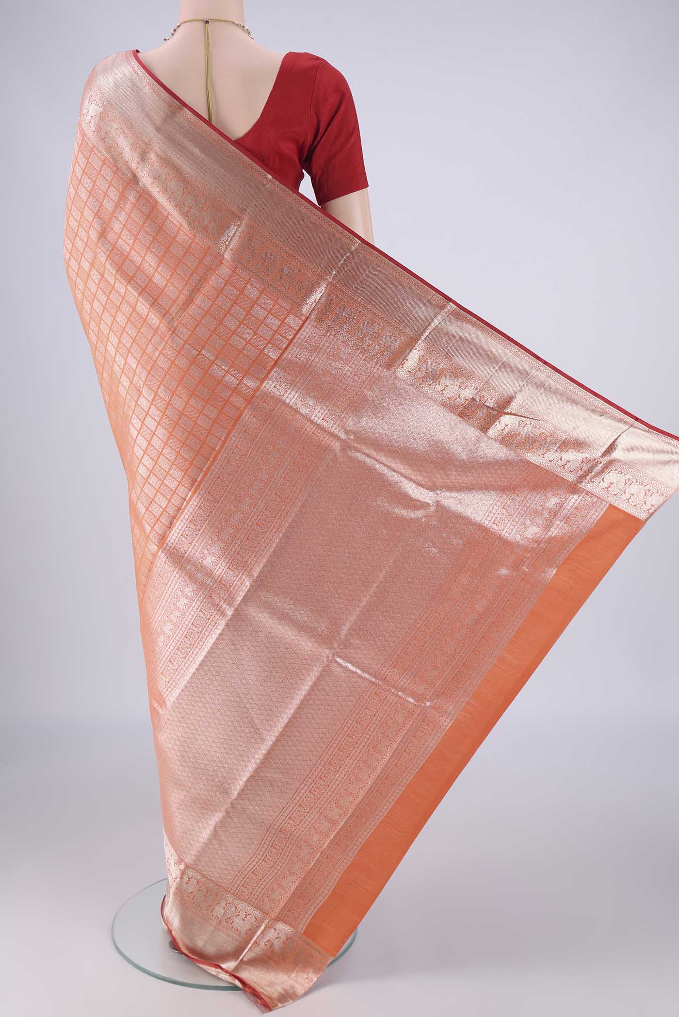 Flat view of Orange Kanchipuram Silk Saree with Zari Brocade on the body and Zari Border. 