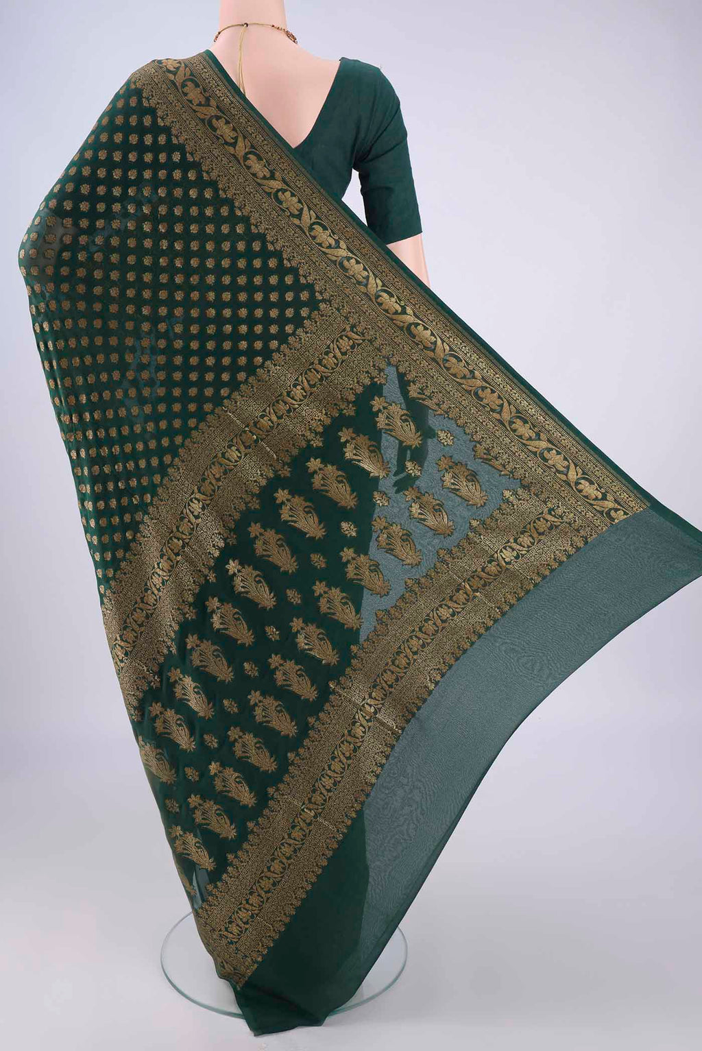 Flat view of Bottle Green Banarasi Georgette Saree with Zari Butta on the body and Zari Border. 