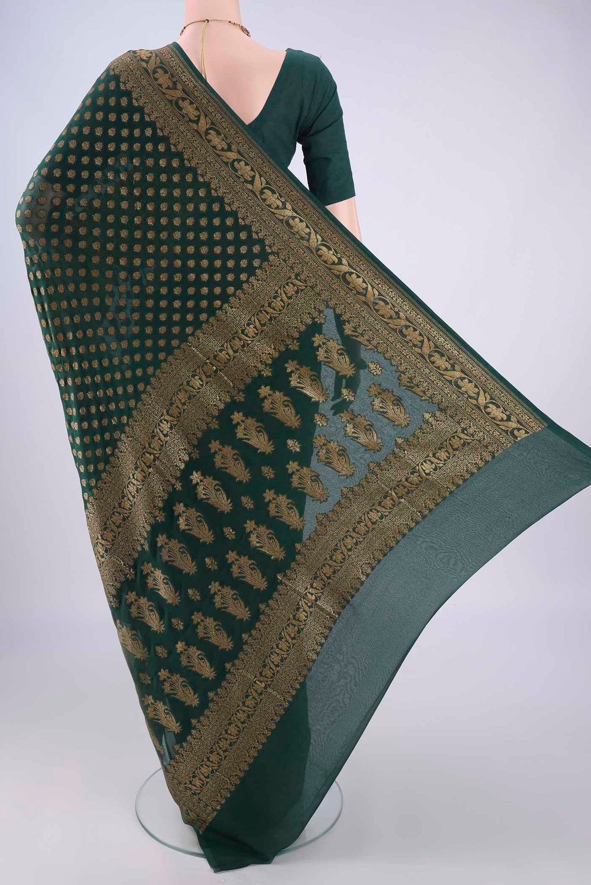 Flat view of Bottle Green Banarasi Georgette Saree with Zari Butta on the body and Zari Border. 