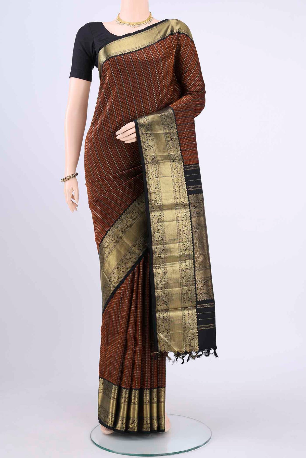 Black Kanchipuram Saree with Zari Butta on the body and Zari Border displayed on a mannequin