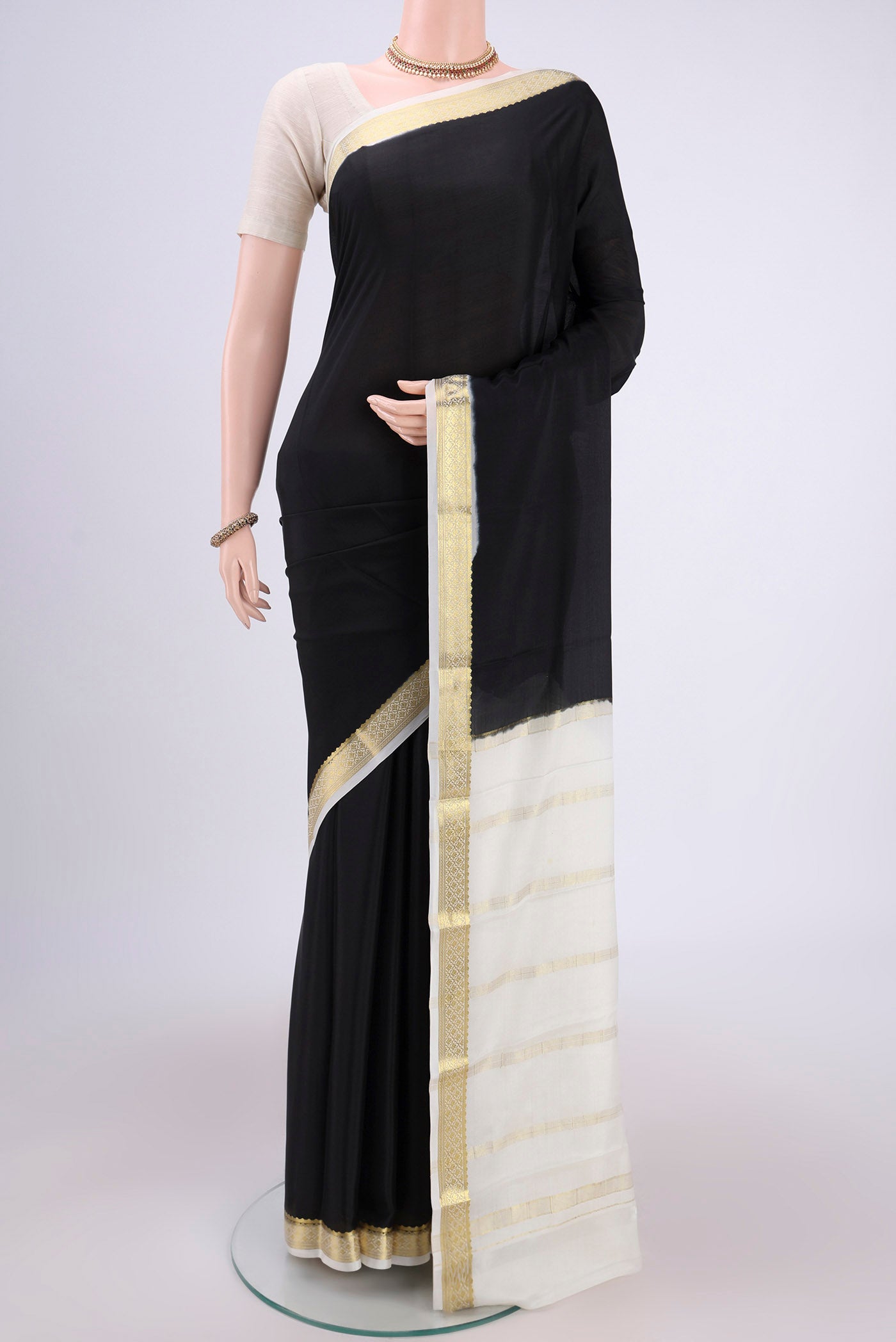 Black Mysore Crepe Saree with Plain Body and Zari Border.  displayed on a mannequin