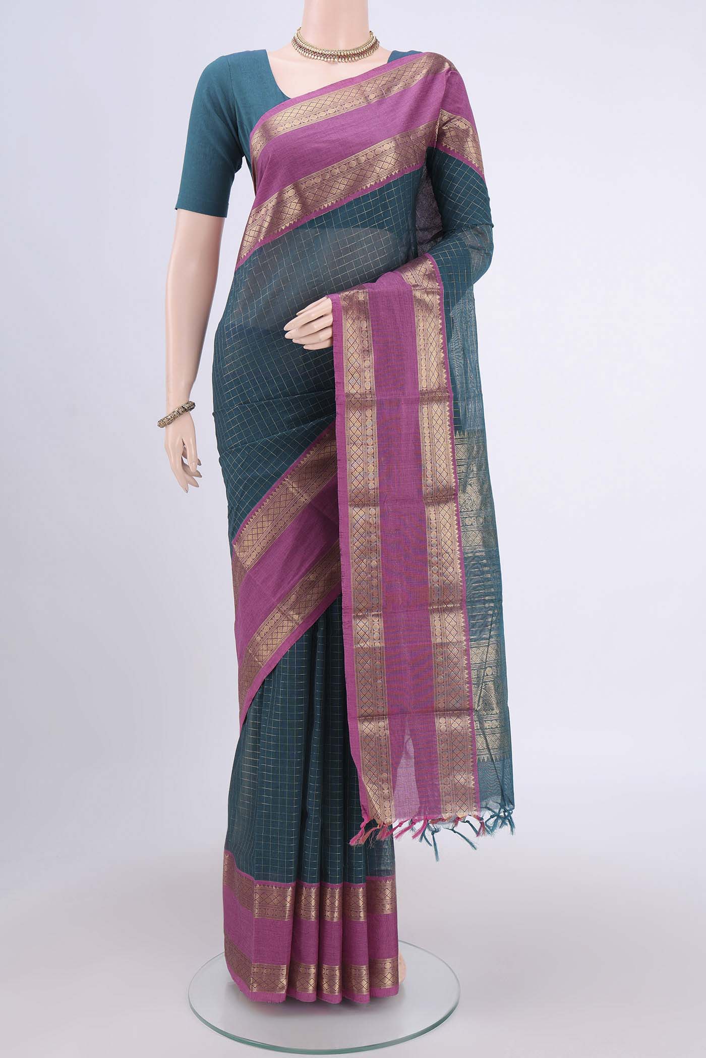 Green Kanchi Cotton Saree with Checked design on the body and Zari Border.  displayed on a mannequin