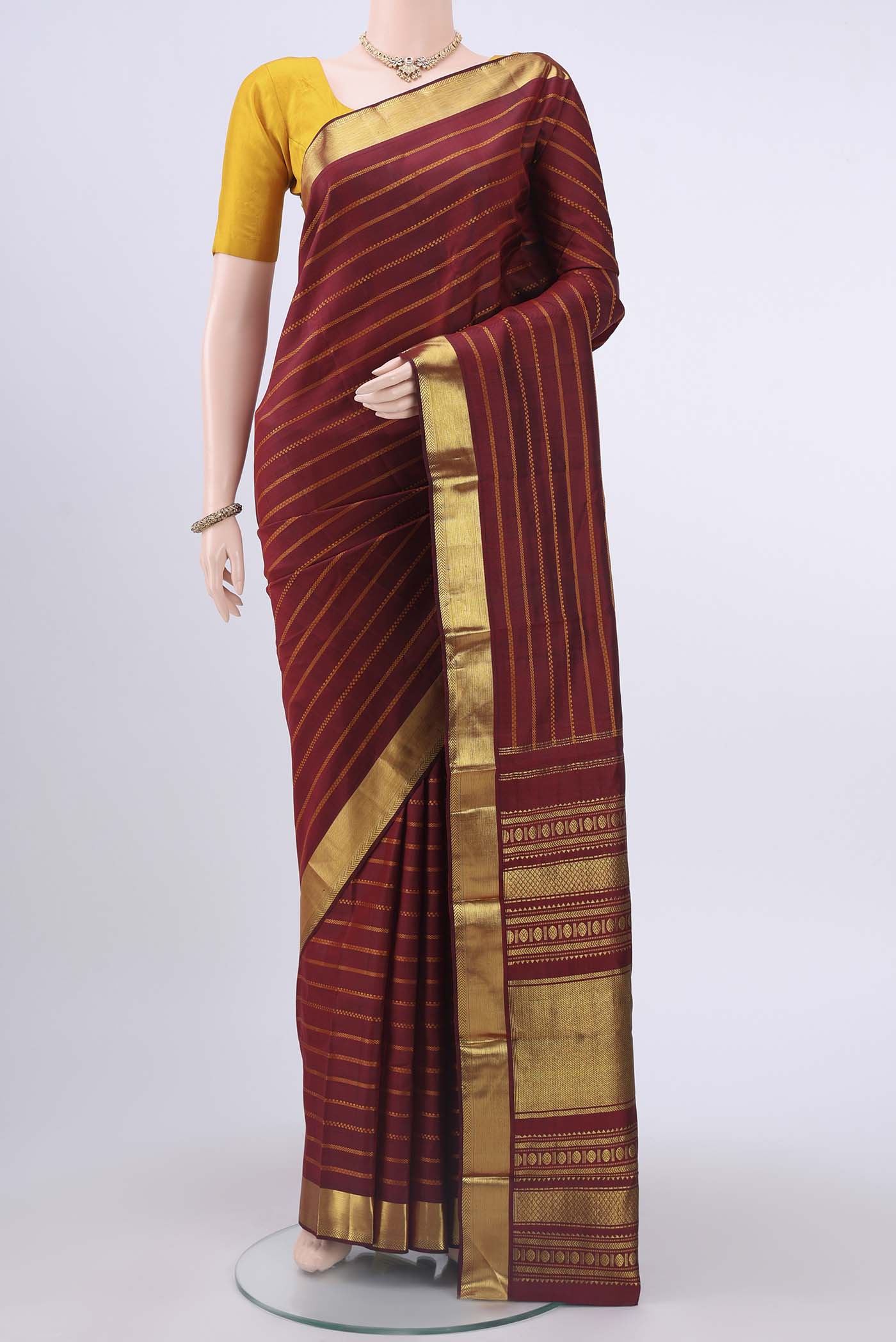 Pure Silk Pure Zari Maroon Kanchipuram Saree with Zari Butta on the body and Zari Border displayed on a mannequin