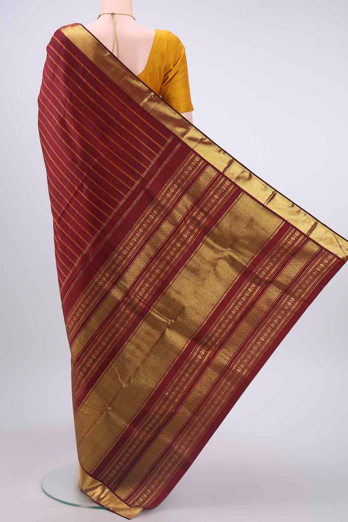Flat view of Pure Silk Pure Zari Maroon Kanchipuram Saree with Zari Butta on the body and Zari Border
