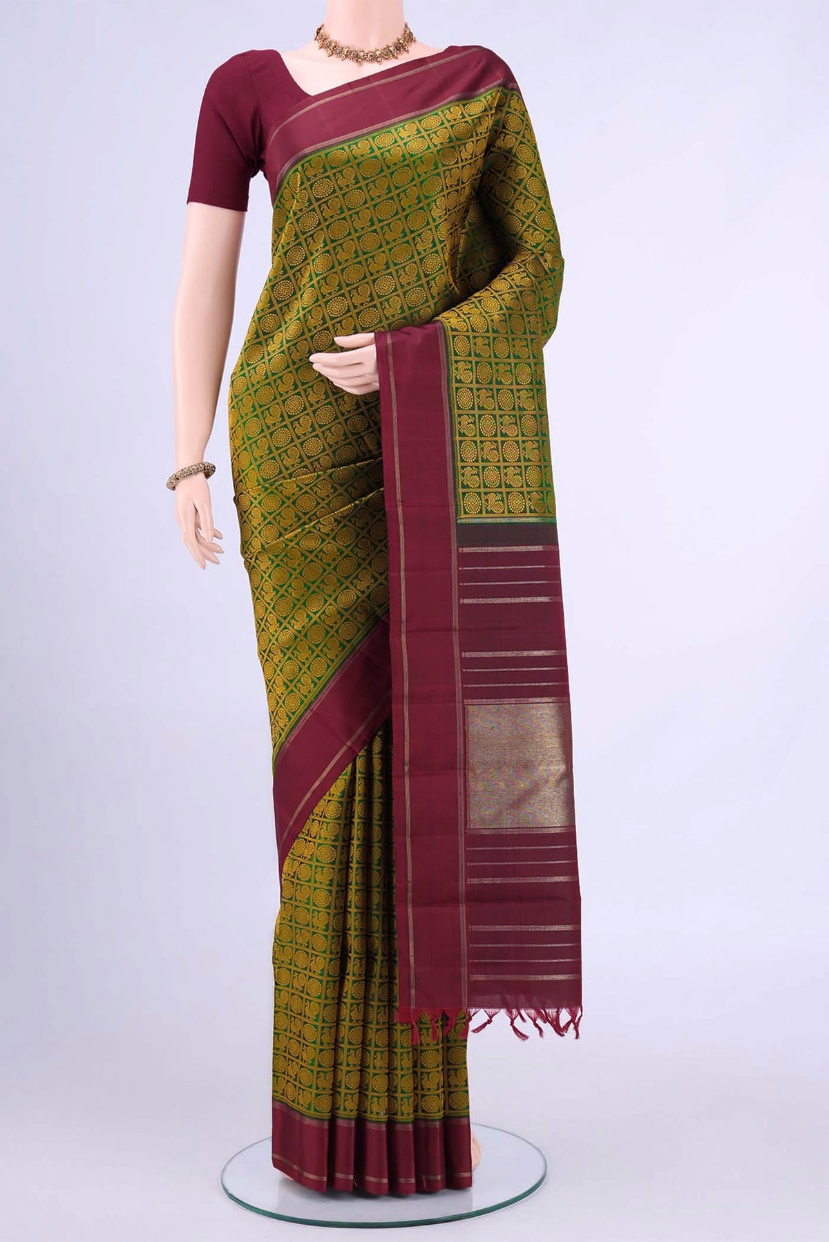 Bottle Green Kanchipuram Saree with Jacquard design on the body and Thin Zari Line displayed on a mannequin