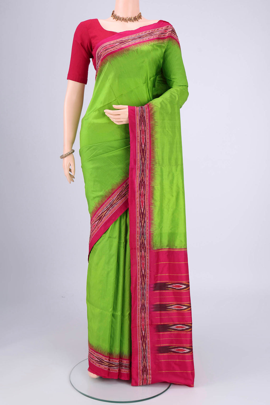 Parrot Green Pochampally Silk Saree with Plain Body and Ikat Border.  displayed on a mannequin