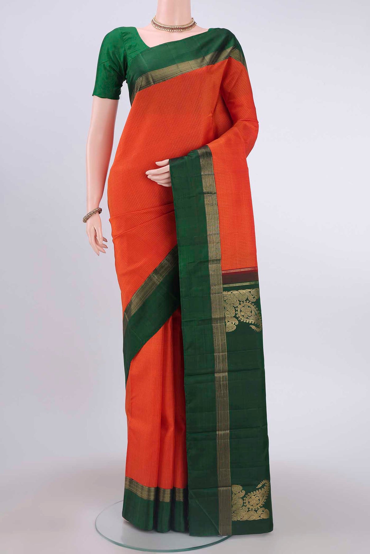 Brick Orange Dual Tone Kanchipuram Saree with Stripes on the body and Zari Border displayed on a mannequin