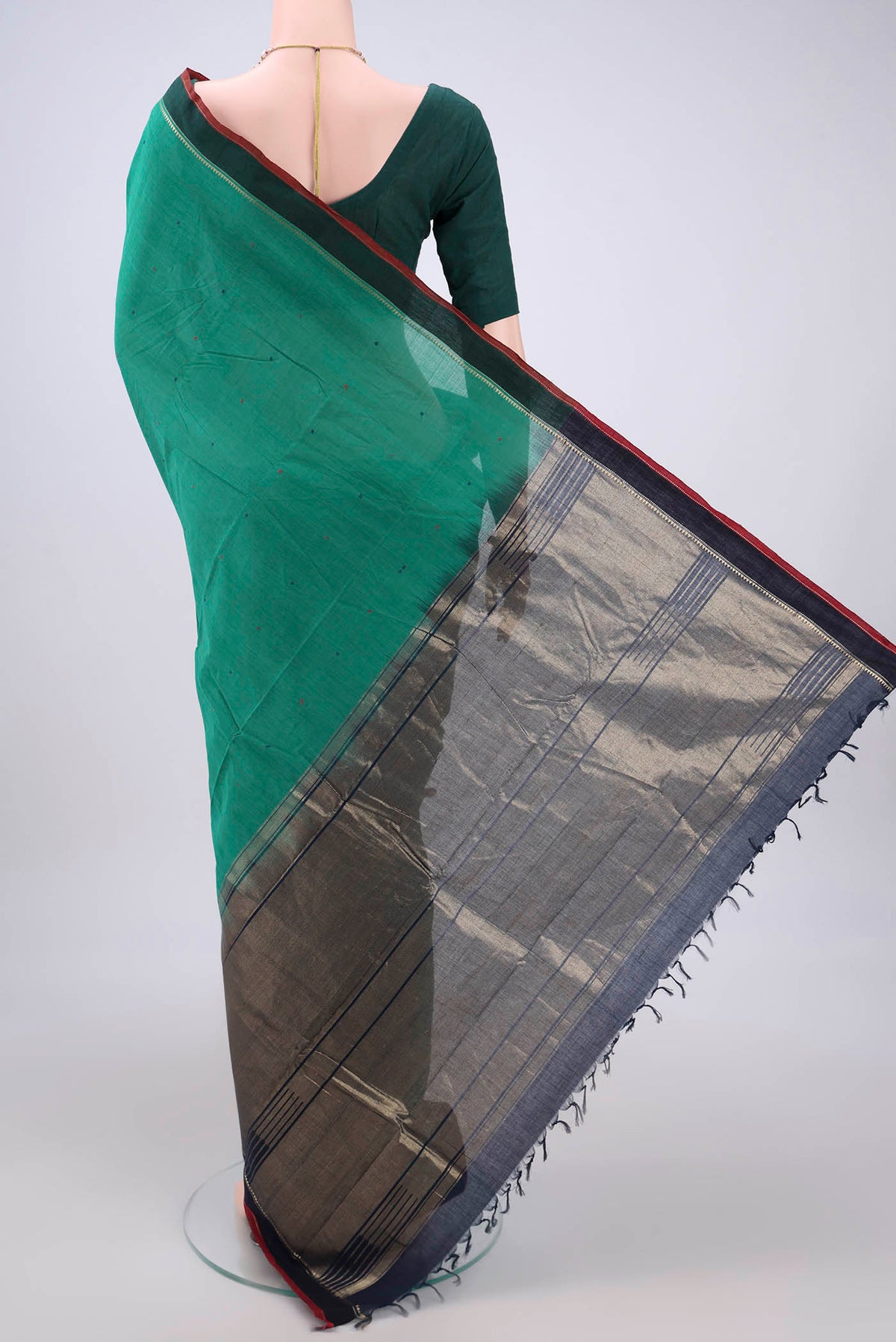 Flat view of Bottle Green Kanchi Cotton Saree with Thread Butta on the body and Zari Border. 