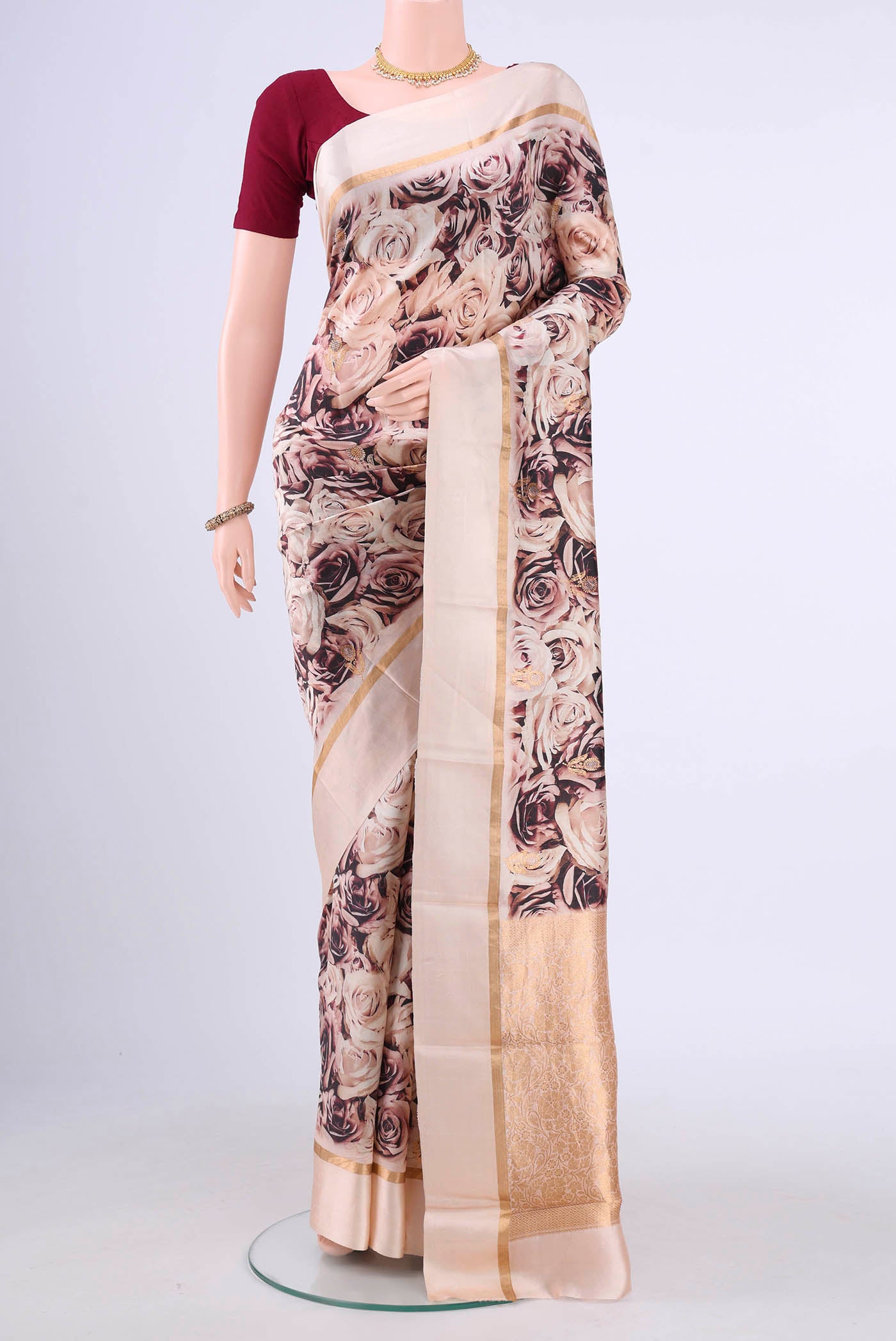 Rose Gold Printed Silk Saree with Printed design on the body and Zari Border displayed on a mannequin