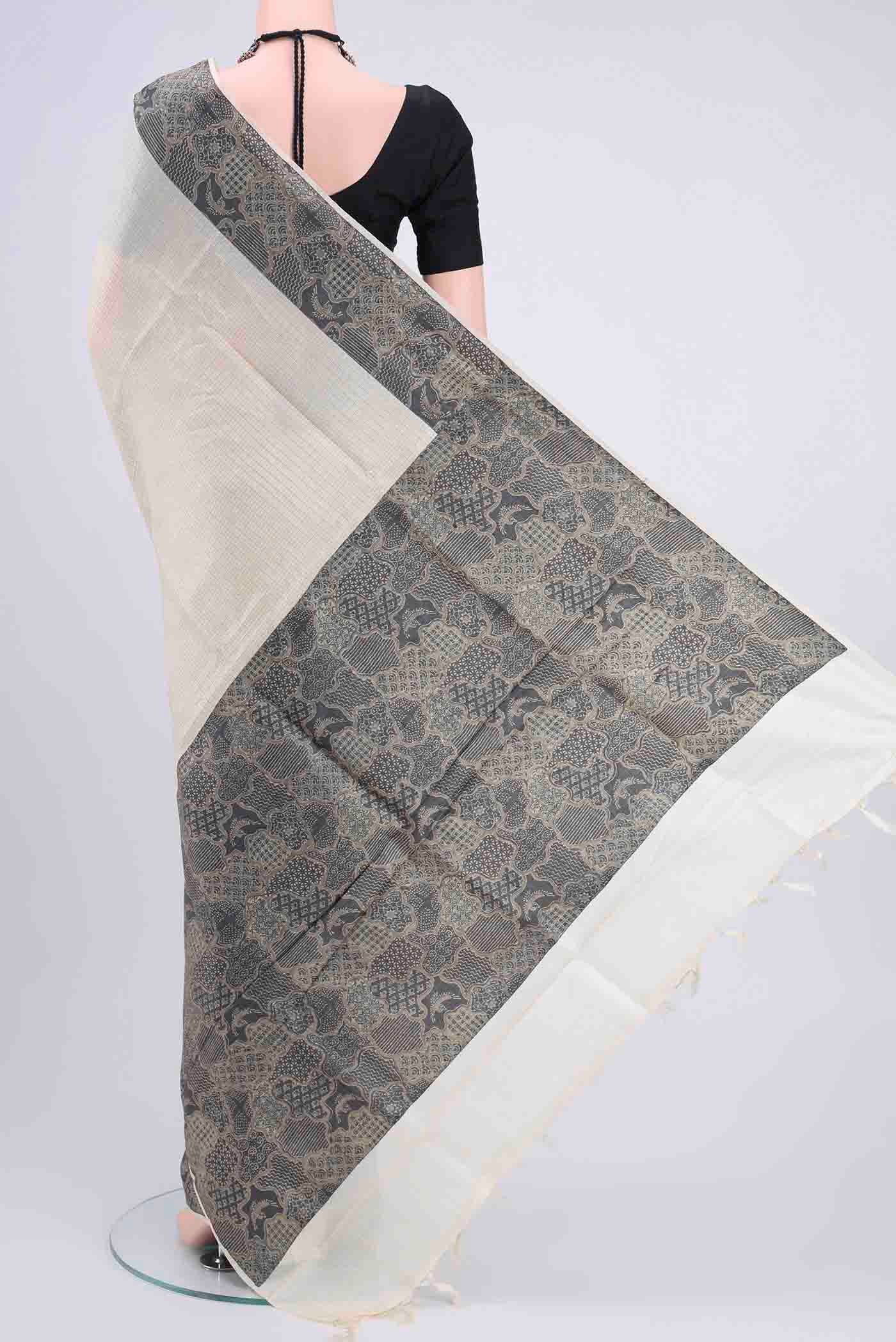 Flat view of Off White Tussar Silk Saree with Zari Butta on the body and Printed Border