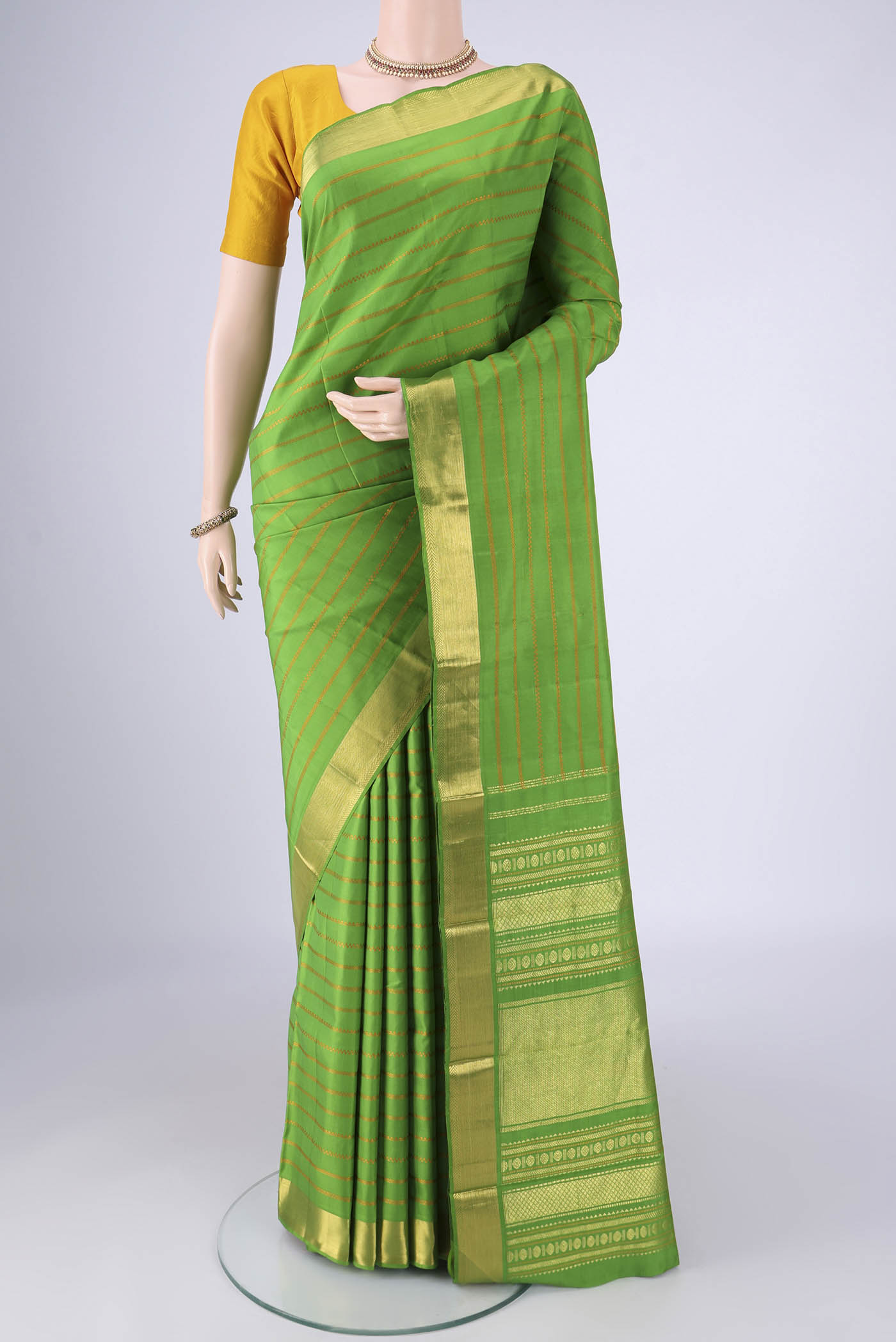 Parrot Green Kanjivaram Silk Saree with Veldhari on the body and Zari Border.  displayed on a mannequin