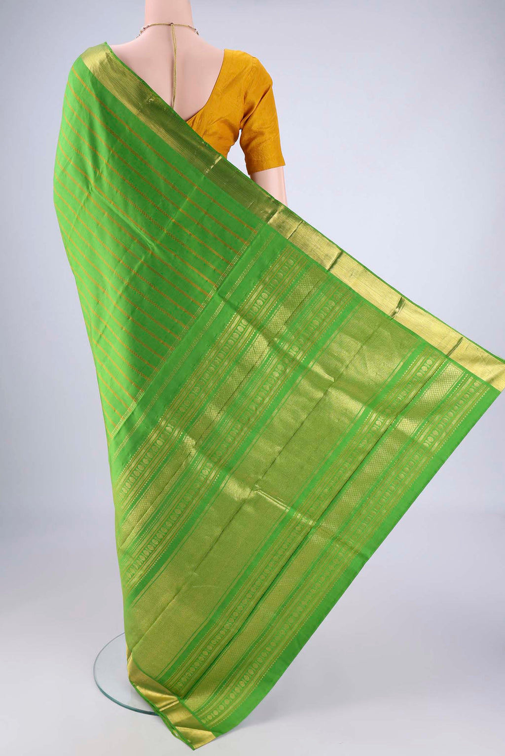 Flat view of Parrot Green Kanjivaram Silk Saree with Veldhari on the body and Zari Border. 