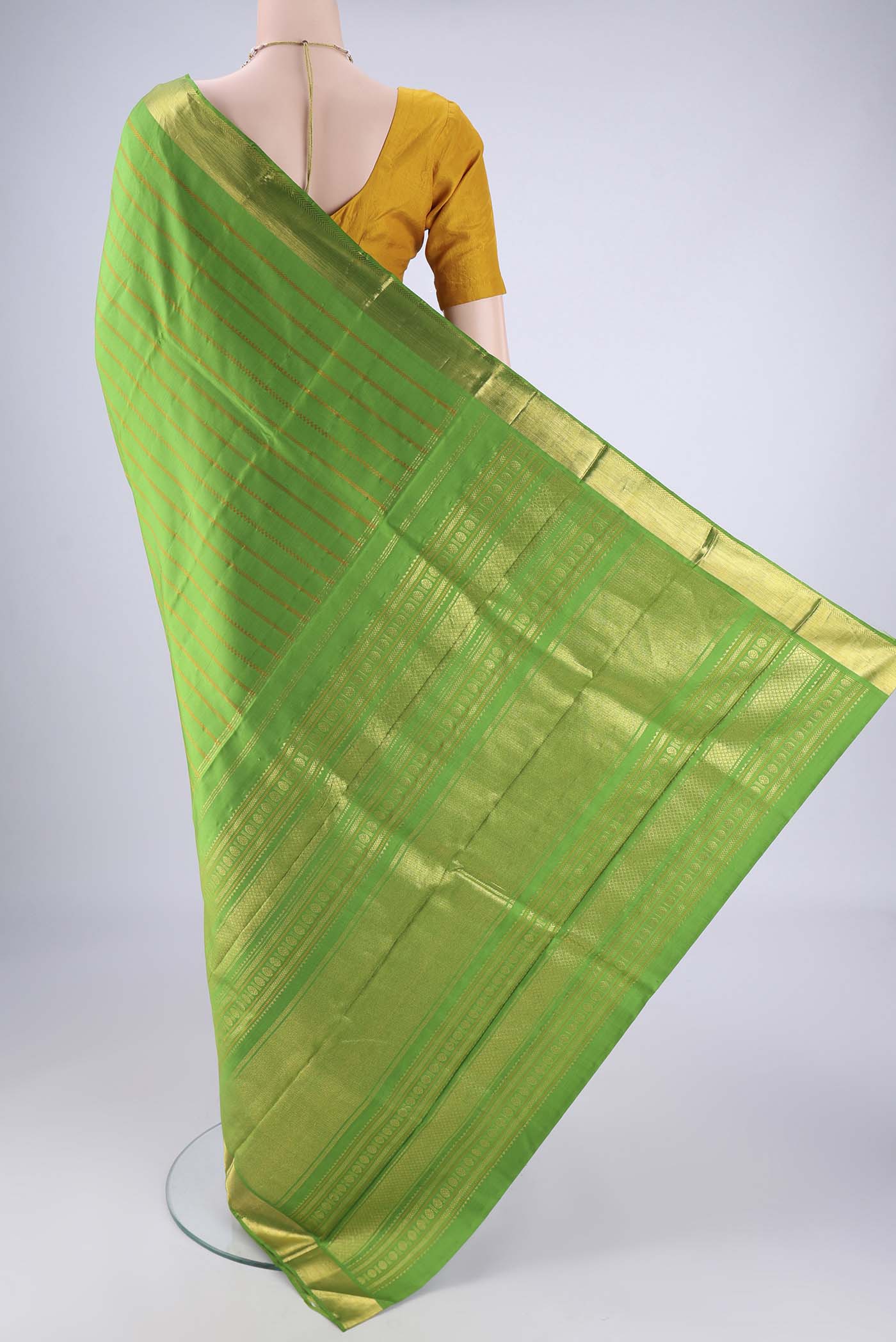 Flat view of Parrot Green Kanjivaram Silk Saree with Veldhari on the body and Zari Border. 