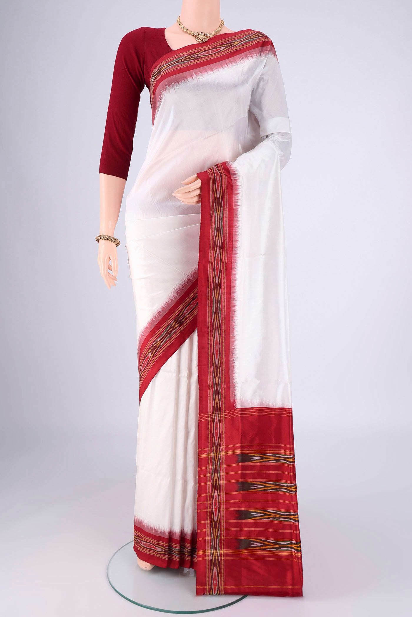 Off White Pochampally Silk Saree with Plain Body and Ikat Border.  displayed on a mannequin