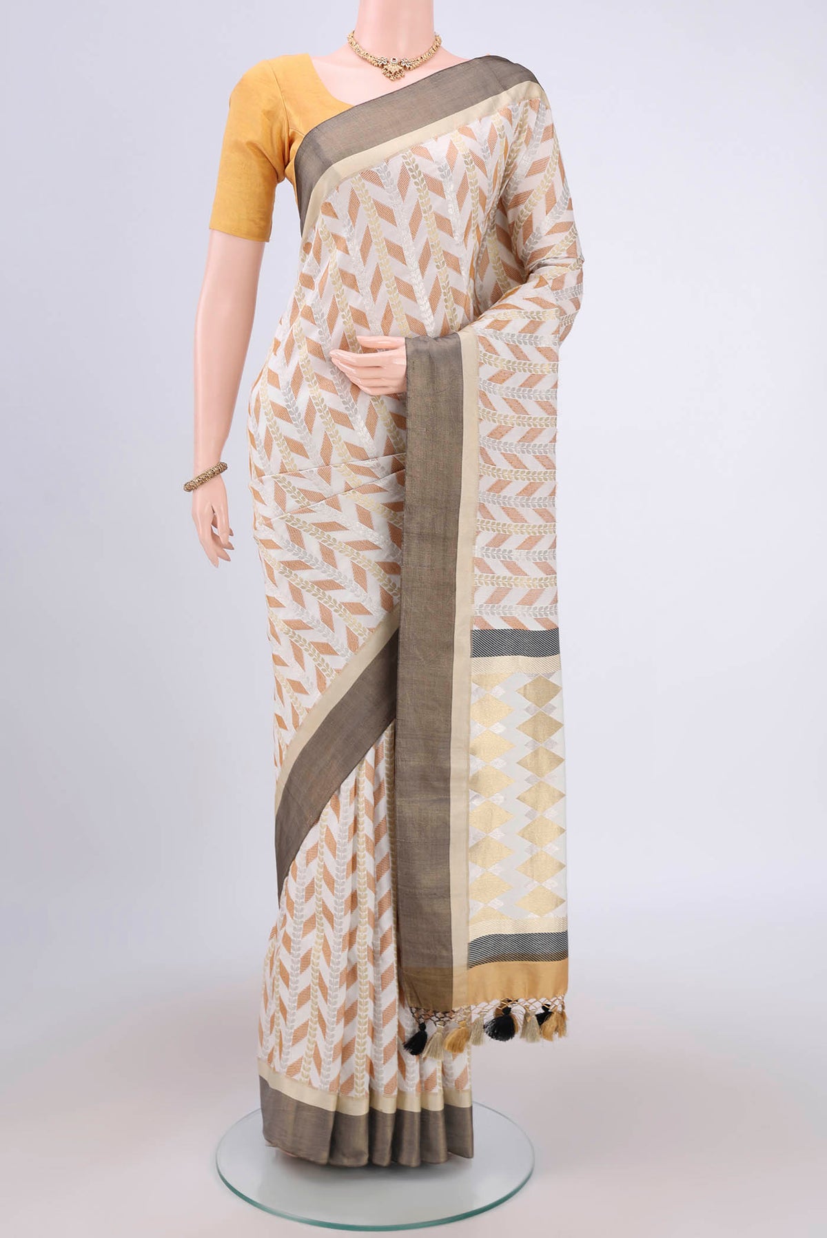 White Soft Silk Saree with Zari Butta on the body and Without Border.  displayed on a mannequin