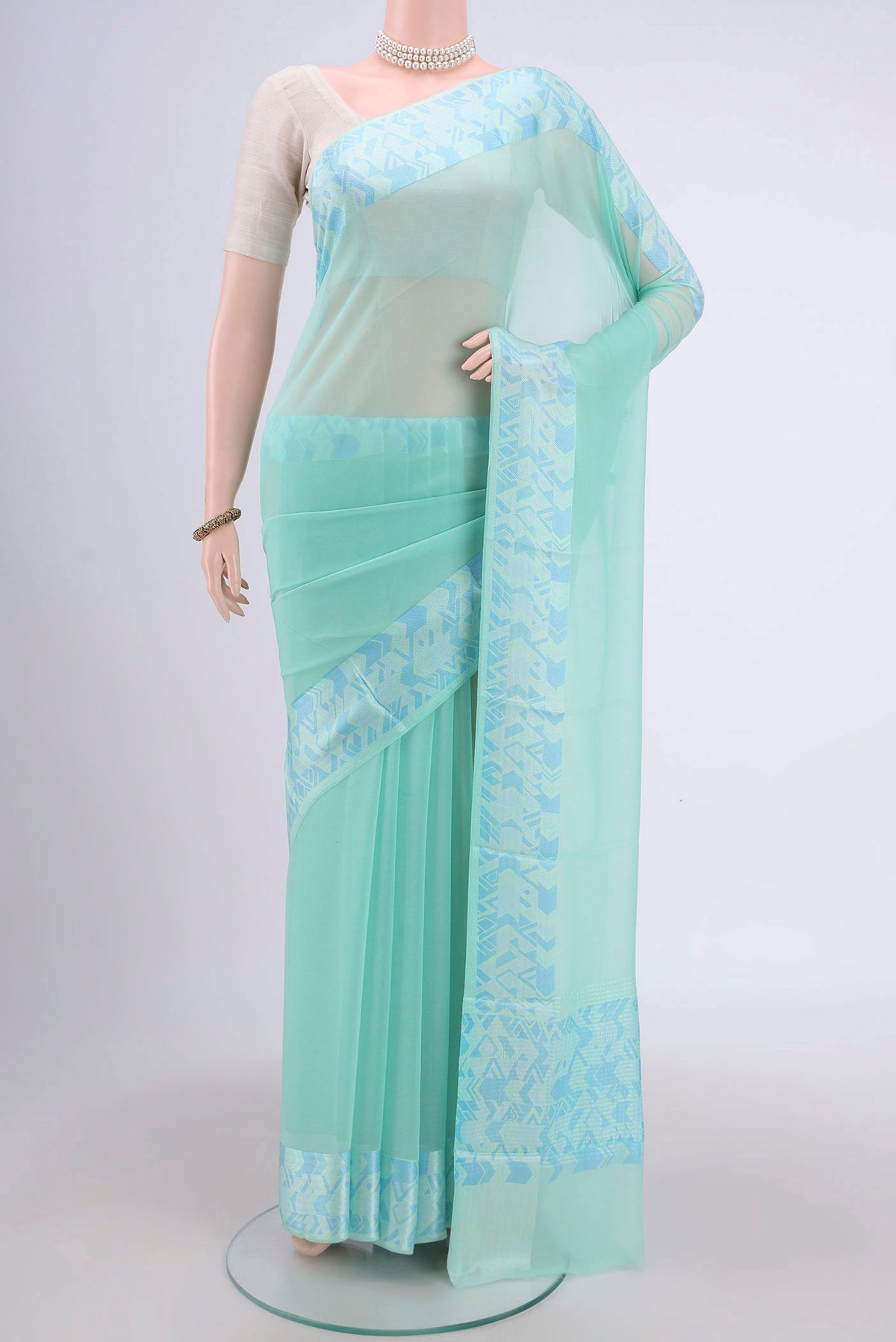 Turquoise Mysore Chiffon Saree with Plain Body and Printed Border.  displayed on a mannequin