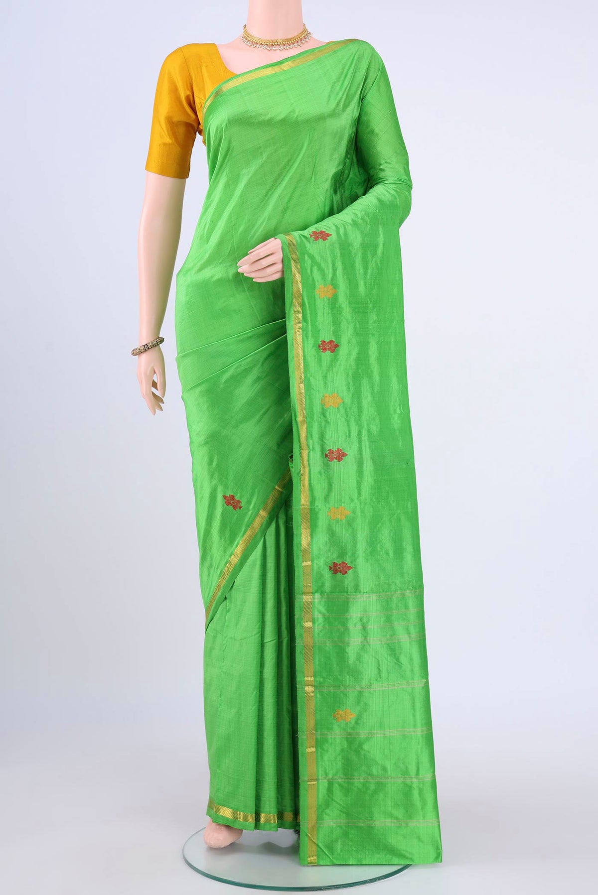Parrot Green Kanchipuram Silk Saree with Plain Body and Zari And Thread Border displayed on a mannequin