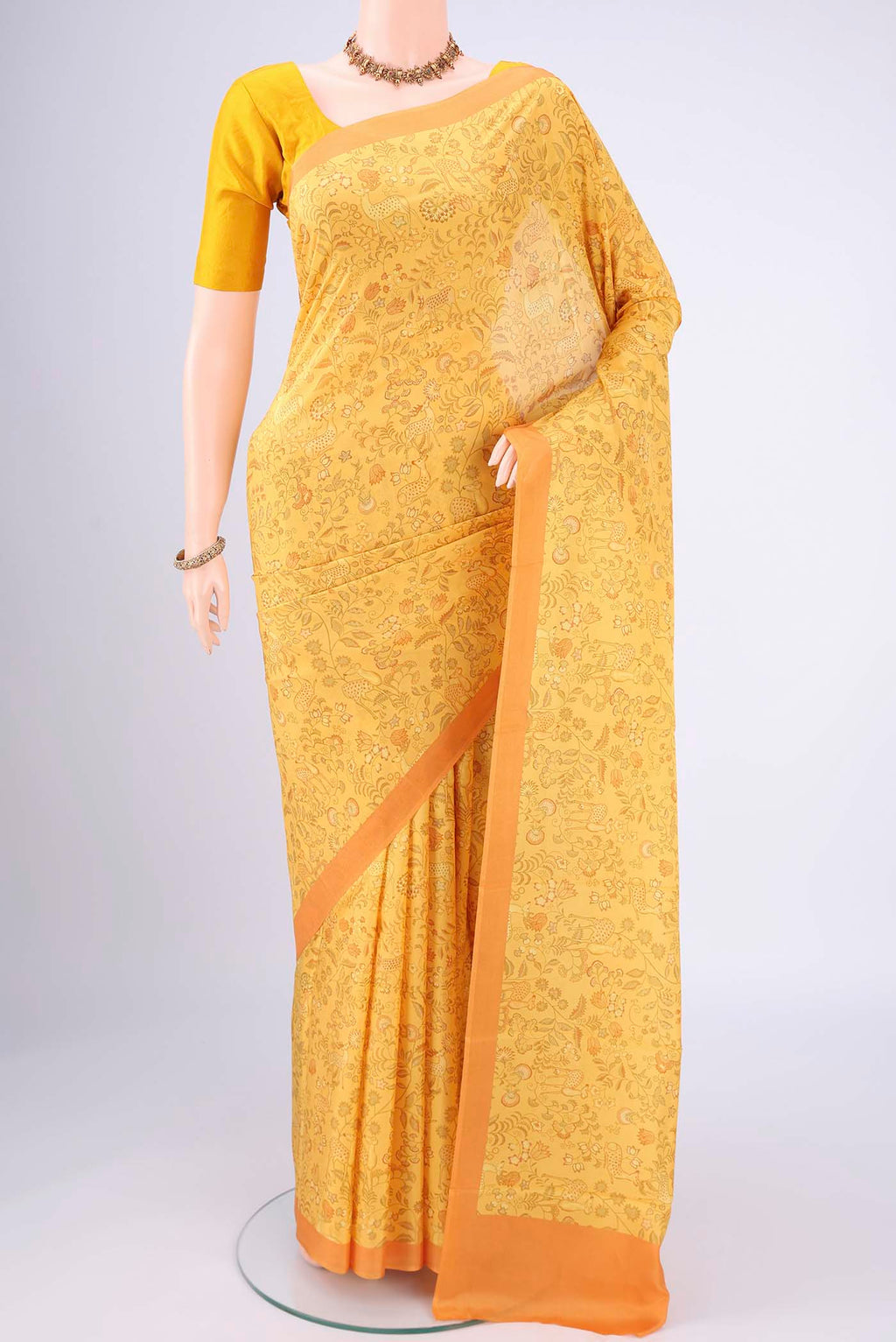 Yellow Printed Silk Saree with Floral Print on the body and Printed Border.  displayed on a mannequin