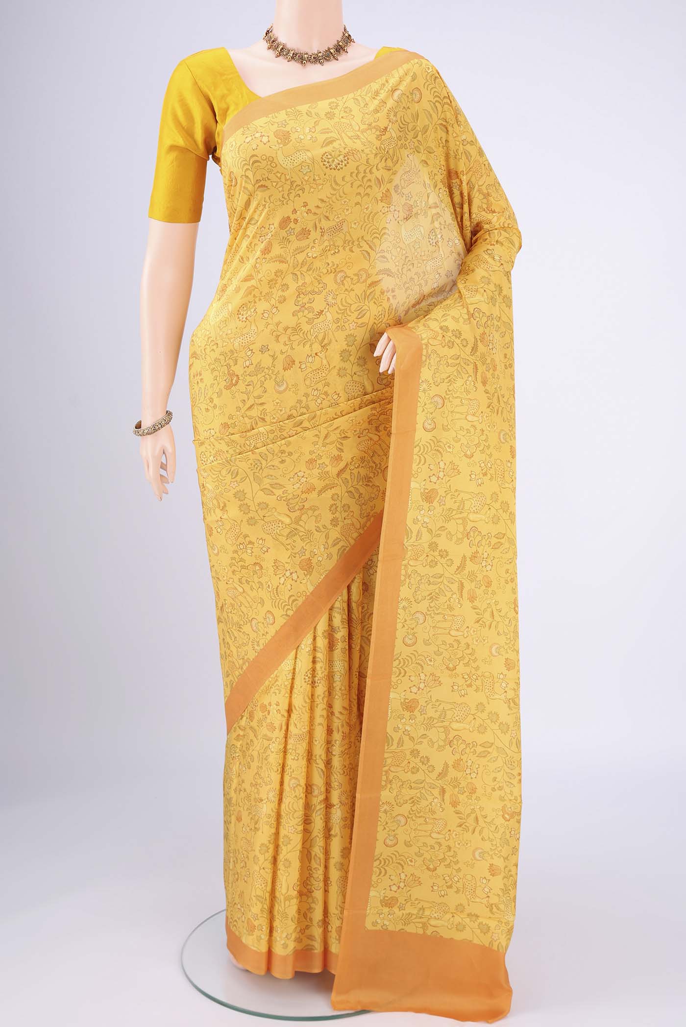 Yellow Printed Silk Saree with Floral Print on the body and Printed Border.  displayed on a mannequin