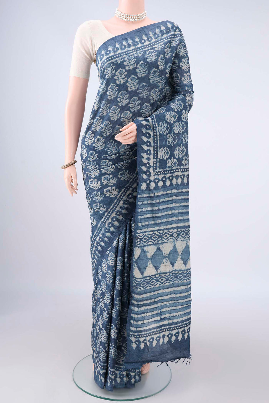 Indigo Tussar Saree with Batik Print on the body and Printed Border.  displayed on a mannequin