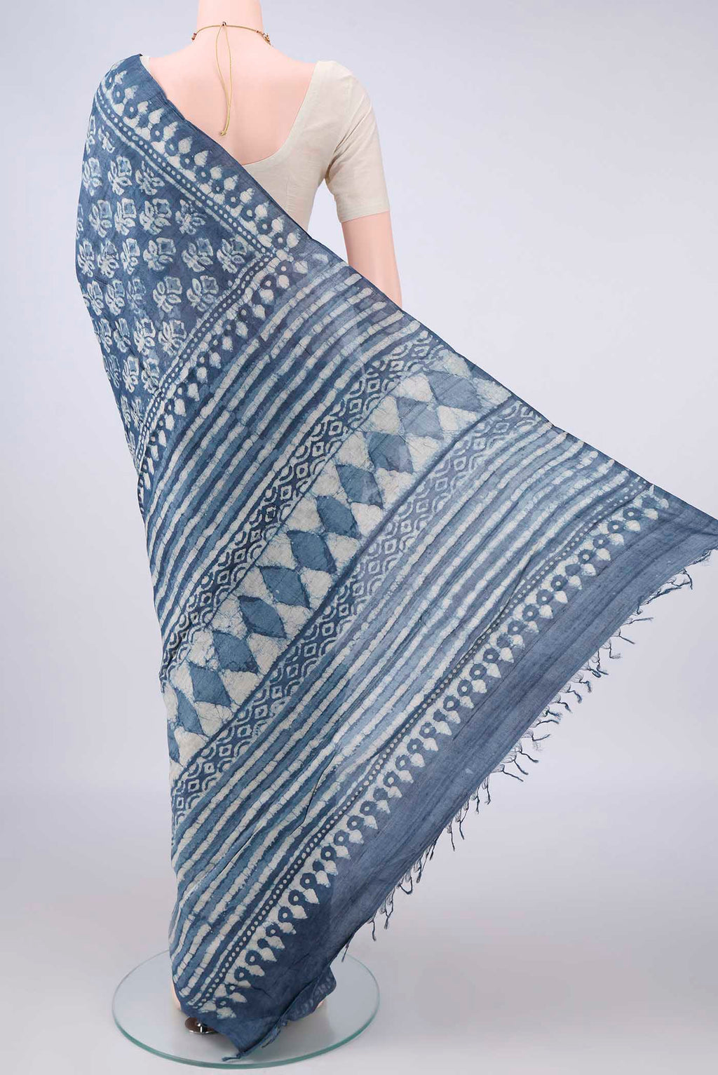 Flat view of Indigo Tussar Saree with Batik Print on the body and Printed Border. 