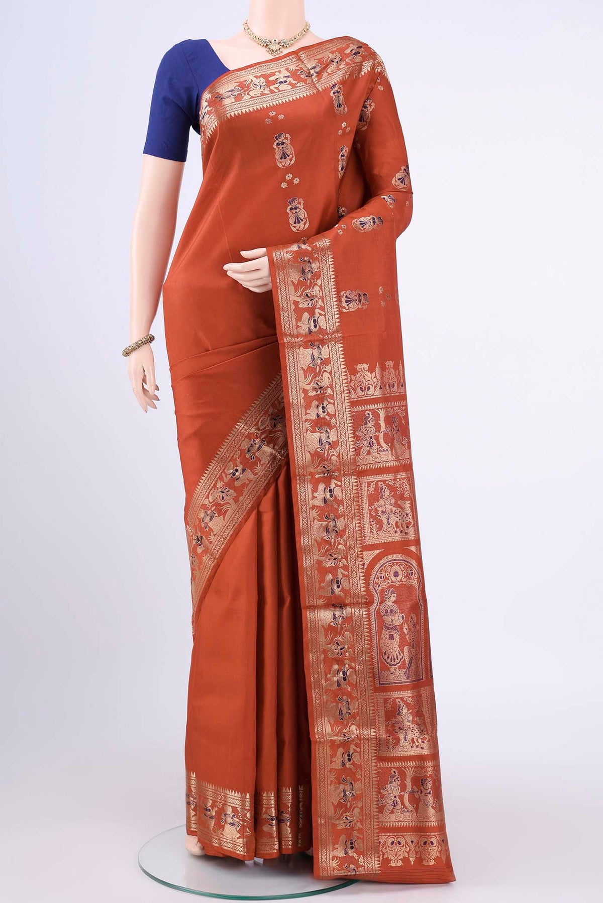 Rust Baluchari Silk Saree with Zari Butta on the body and Zari Border displayed on a mannequin