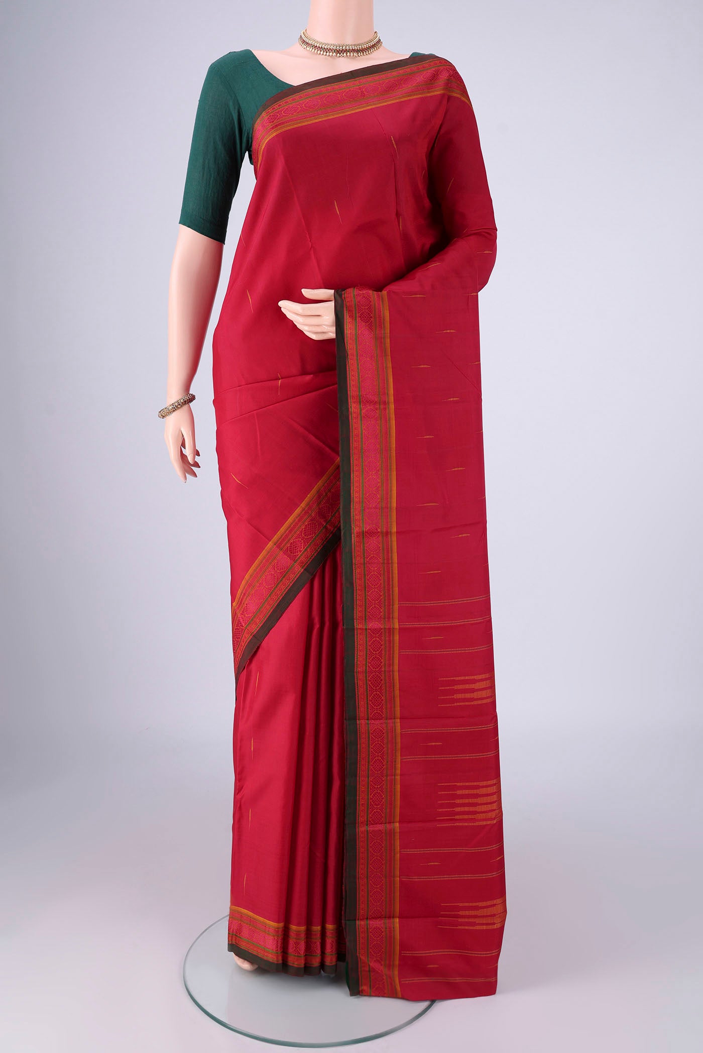 Maroon Kanchipuram Silk Saree with Thread Butta on the body and Thread Border.  displayed on a mannequin