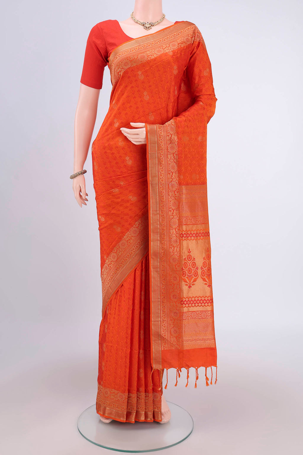 Orange Soft Silk Saree with Jacquard design on the body and Thread Border.  displayed on a mannequin