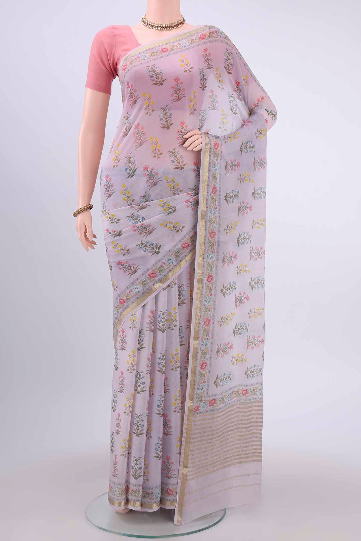 Lavender Mysore Georgette Saree with Floral Print on the body and Zari Border displayed on a mannequin
