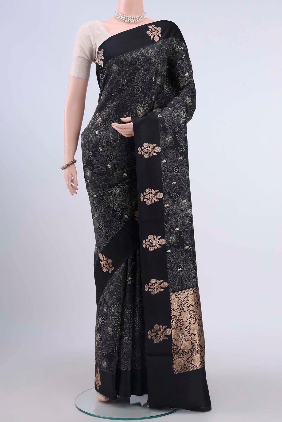 Black Printed Silk Saree with Floral Print on the body and Zari Border displayed on a mannequin