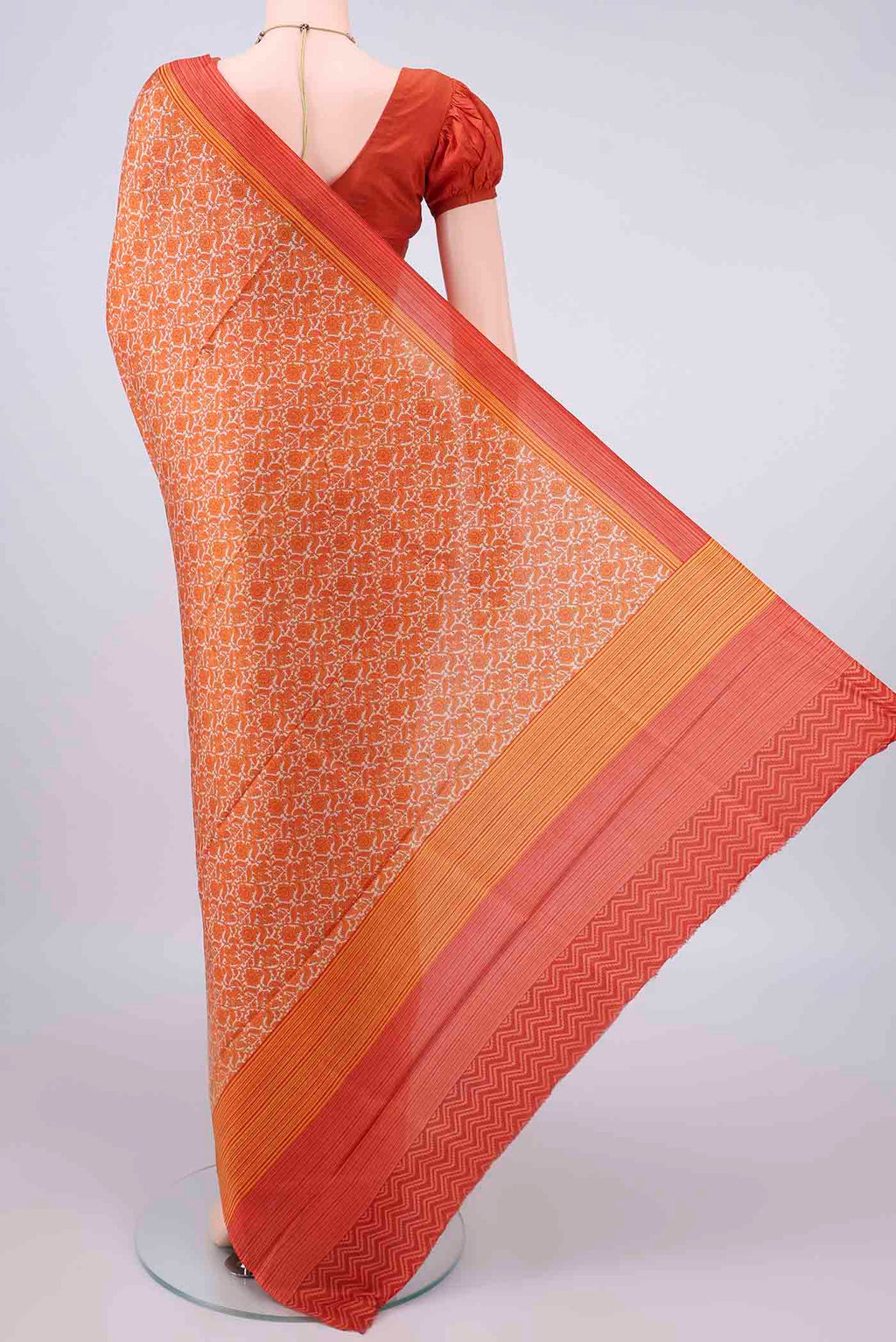 Flat view of Pure Silk Orange Printed Saree with Printed design on the body and Plain Border. 