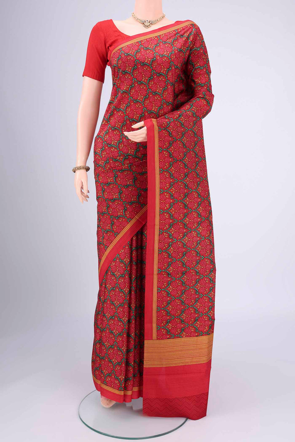 Red Printed Silk Saree with Floral Print on the body and Printed Border.  displayed on a mannequin