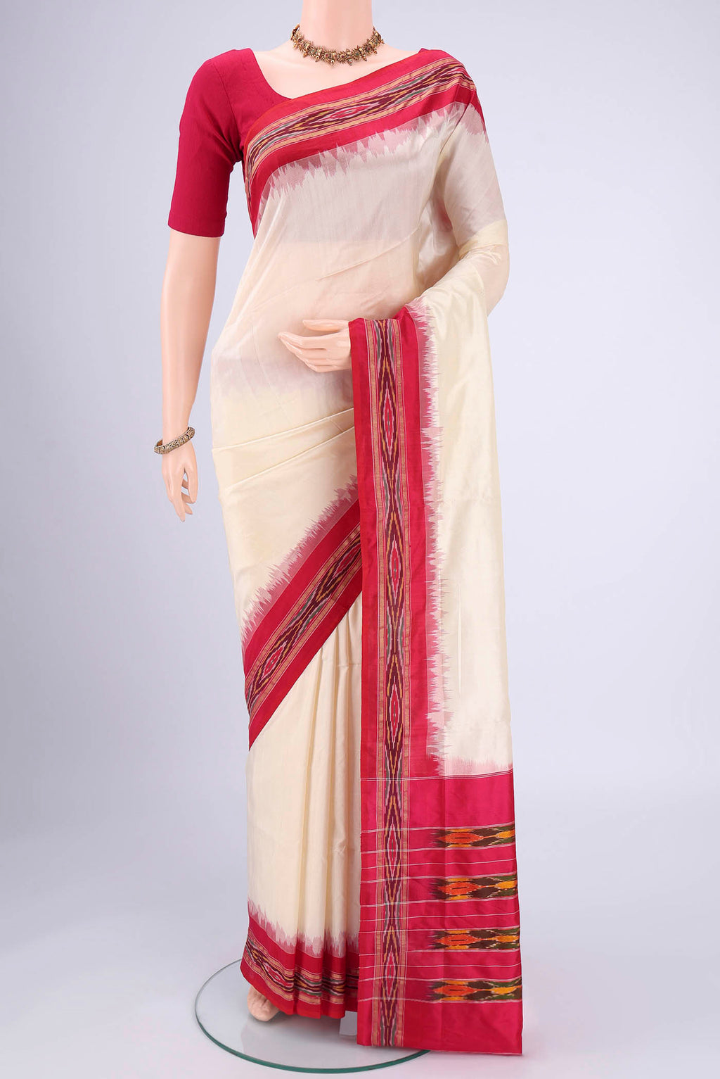Off White Pochampally Silk Saree with Plain Body and Ikat Border.  displayed on a mannequin