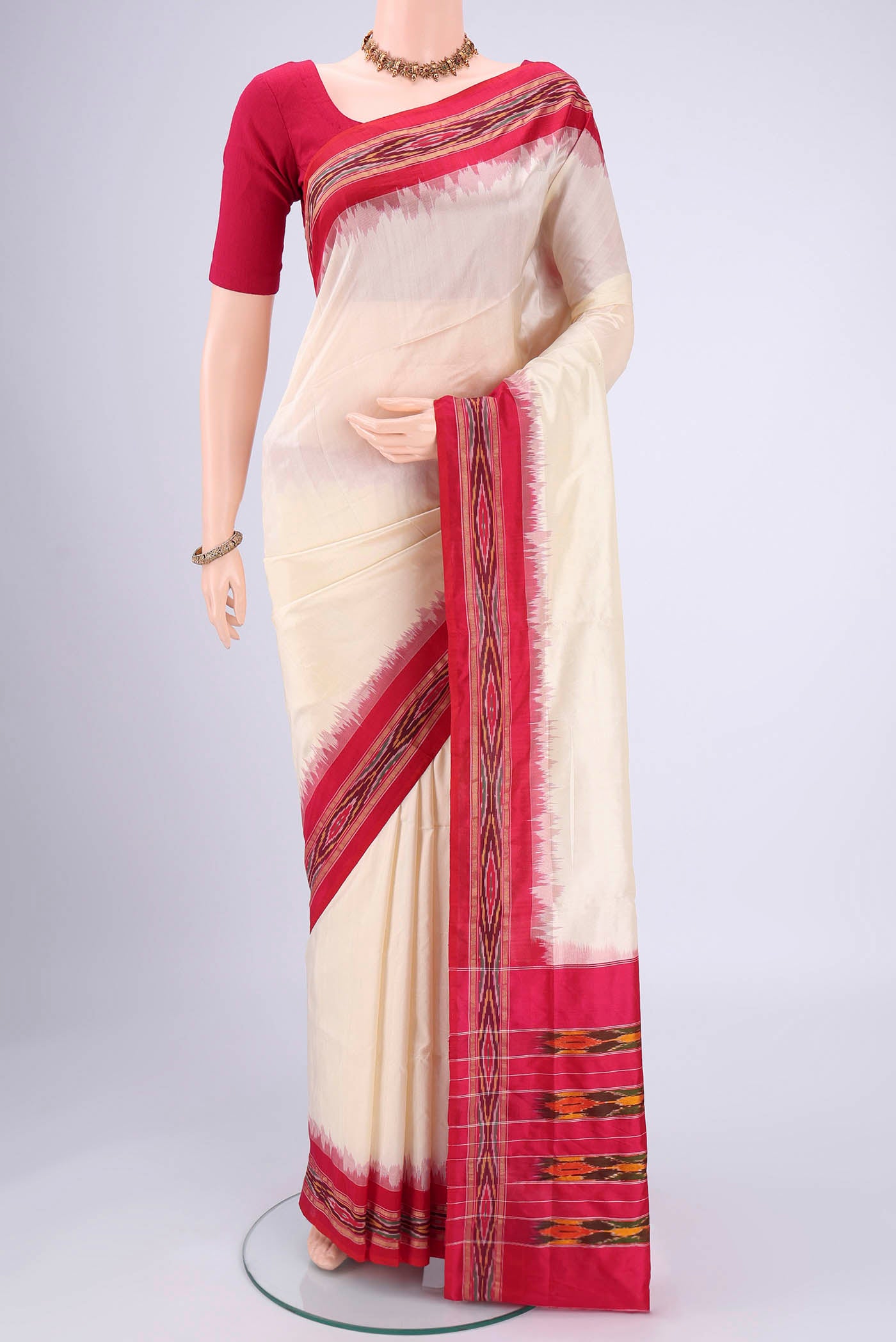 Off White Pochampally Silk Saree with Plain Body and Ikat Border.  displayed on a mannequin