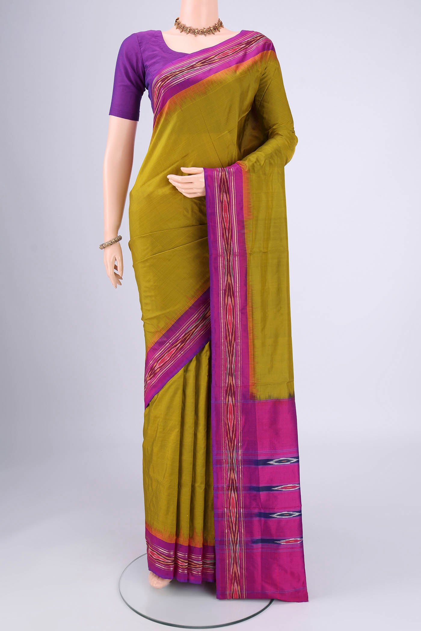 Mehandi Green Pochampally Silk Saree with Ikat design on the body and Ikat Border.  displayed on a mannequin