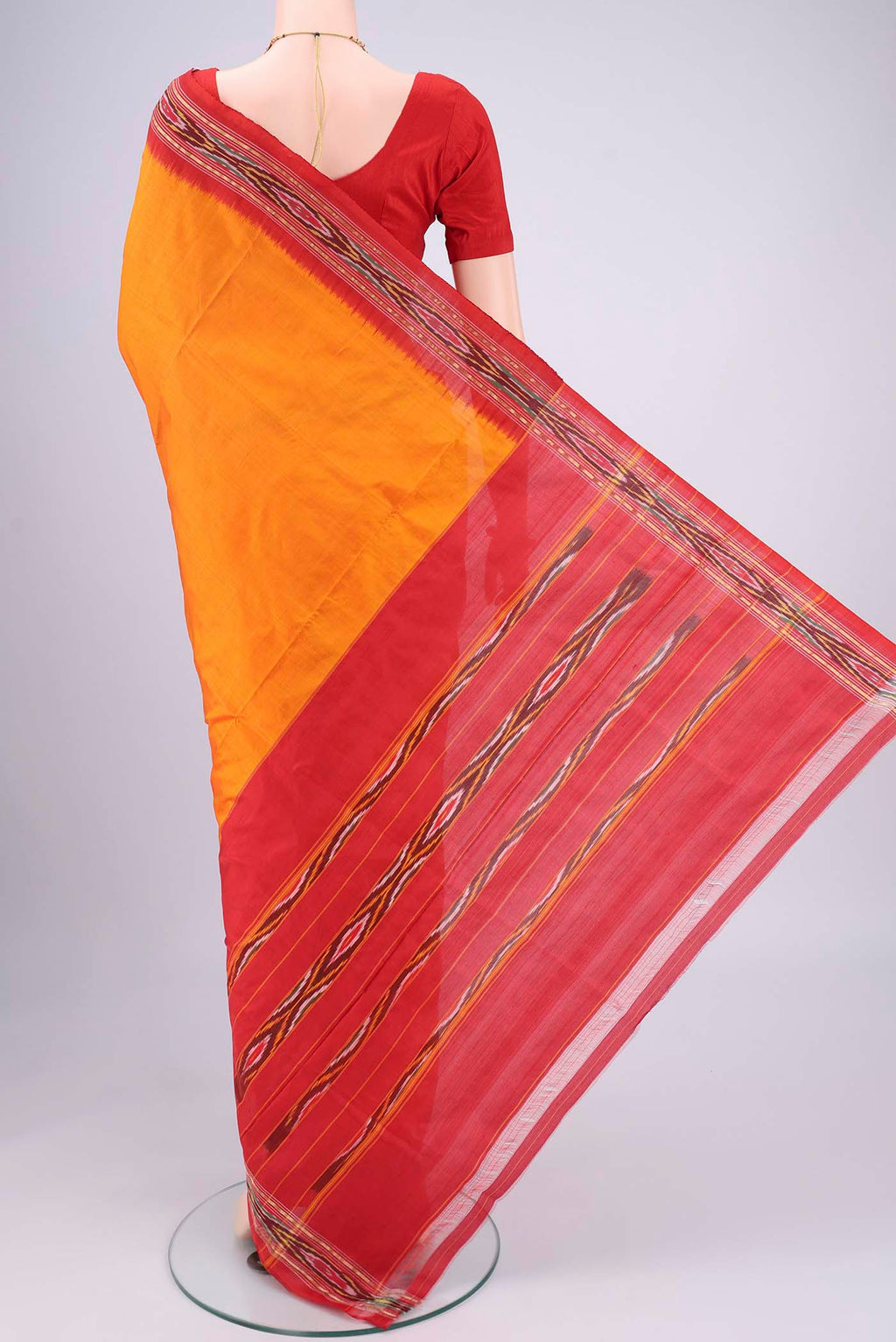 Flat view of Orange Pochampally Silk Saree with Plain Body and Ikat Border. 