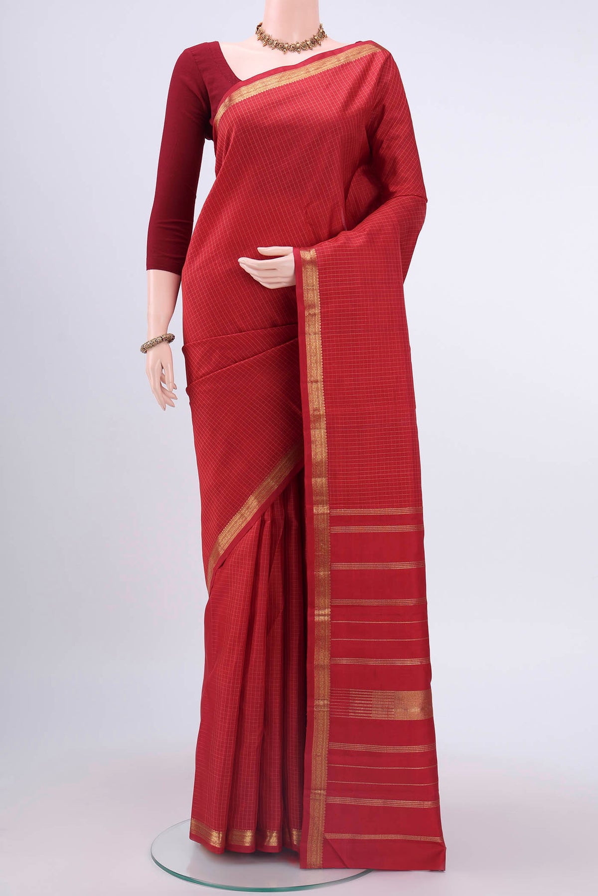 Red Kanchipuram Silk Saree with Checked design on the body and Zari Border displayed on a mannequin