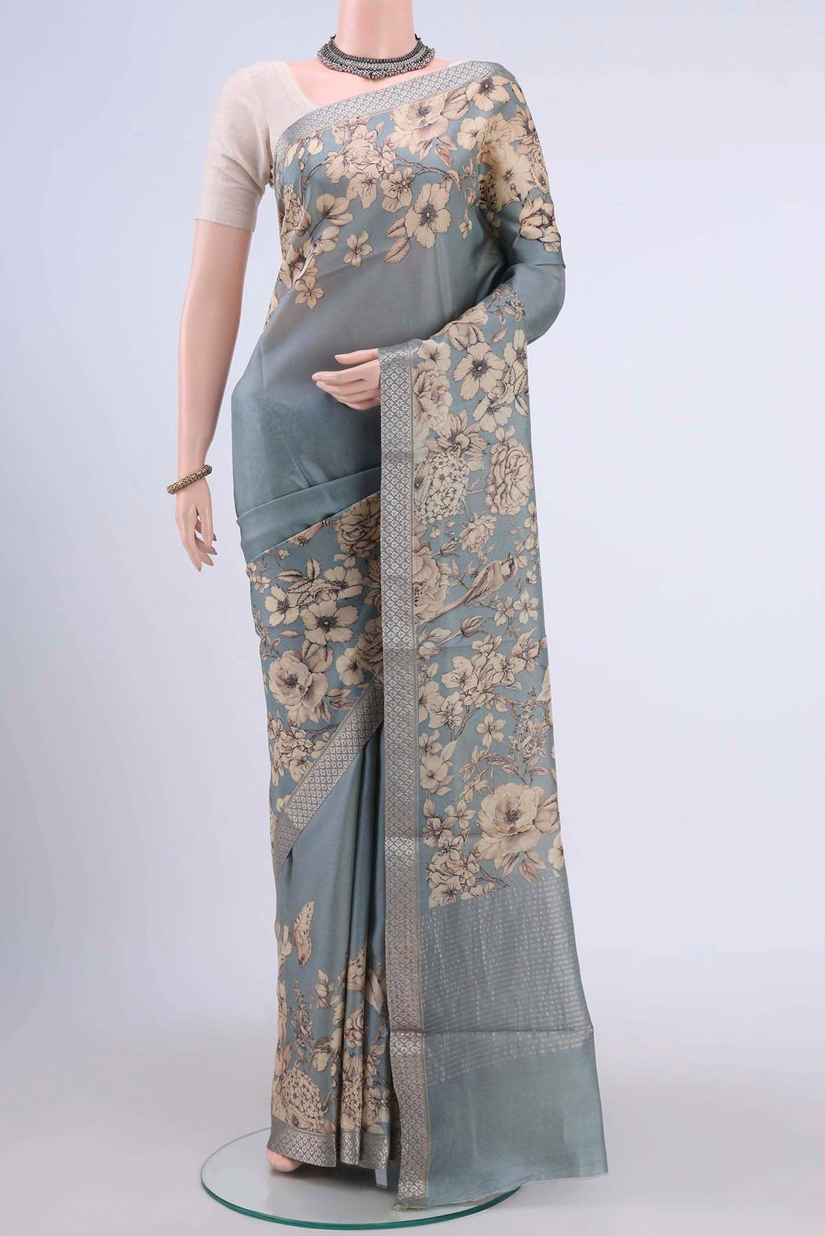 Grey Tussar Silk Saree with Floral Print on the body and Zari Border displayed on a mannequin