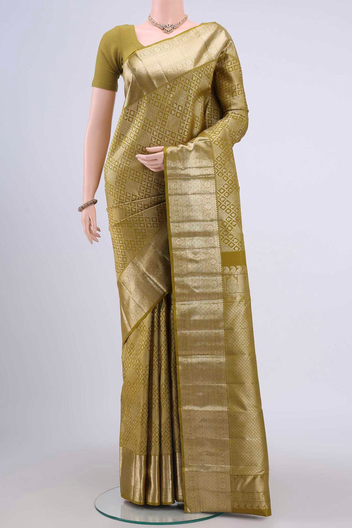 Light Green Kanchipuram Silk Saree with Zari Brocade on the body and Zari Border displayed on a mannequin