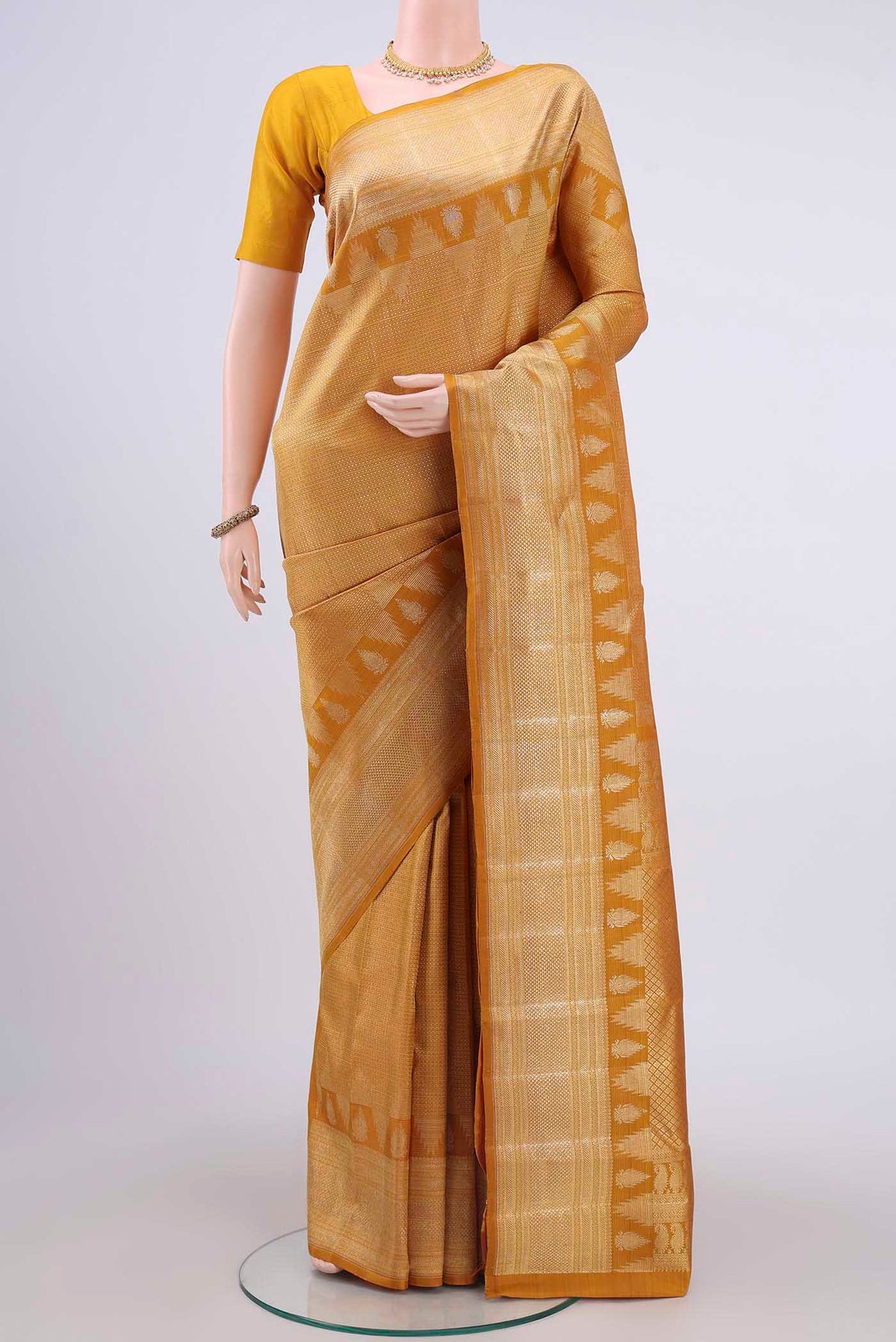 Mustard Kanchipuram Silk Saree with Zari Brocade on the body and Zari Border displayed on a mannequin