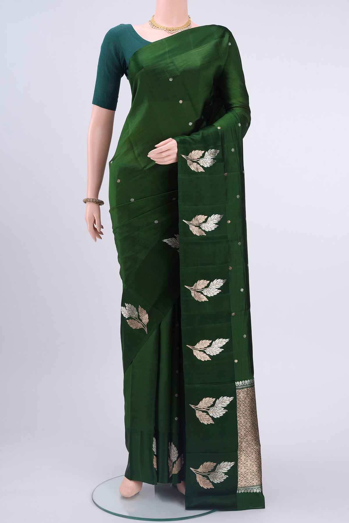 Bottle Green Banarasi Katan Silk Saree with Zari Butta on the body and Zari Border displayed on a mannequin