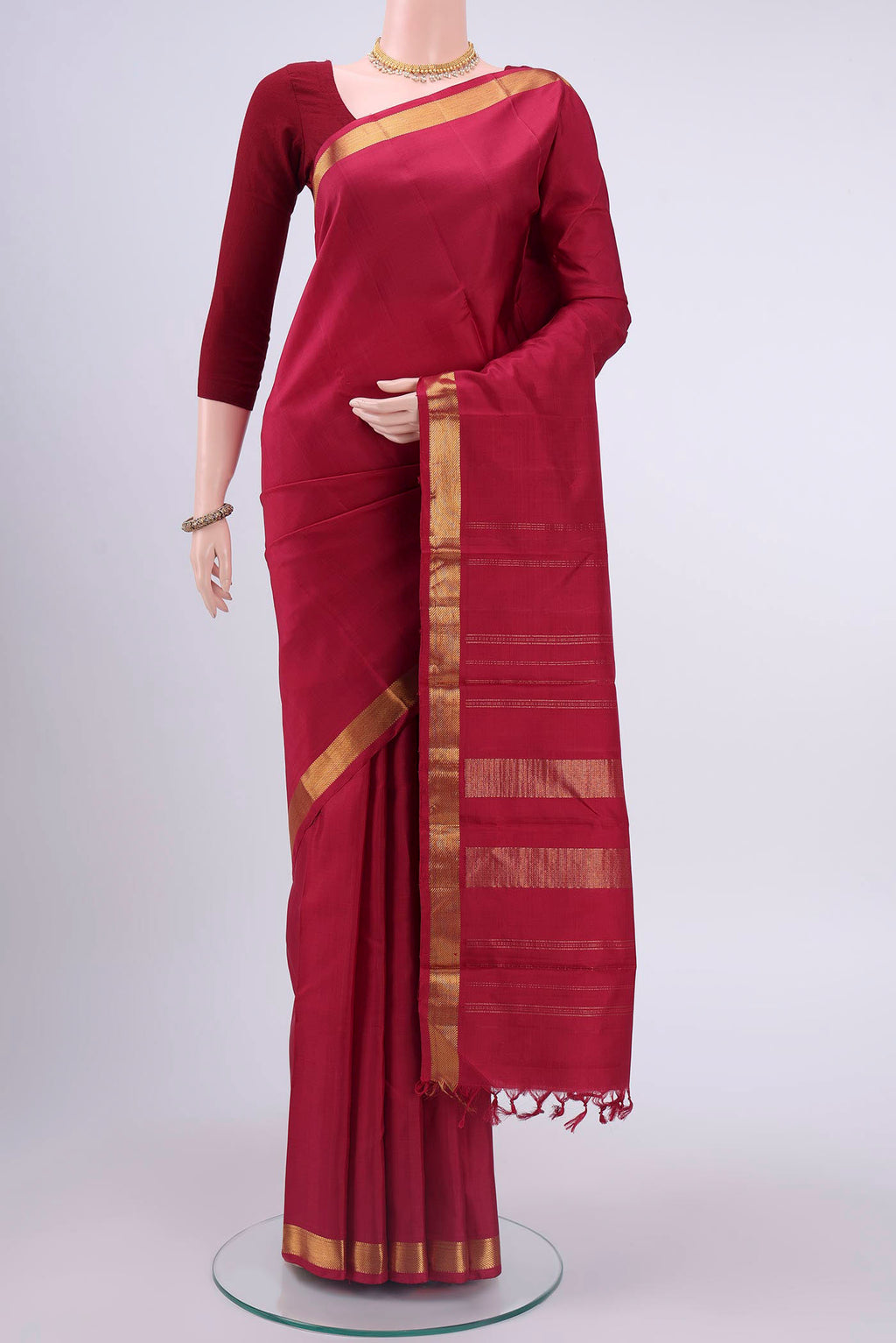 Maroon Kanchipuram Silk Saree with Plain Body and Zari Border displayed on a mannequin