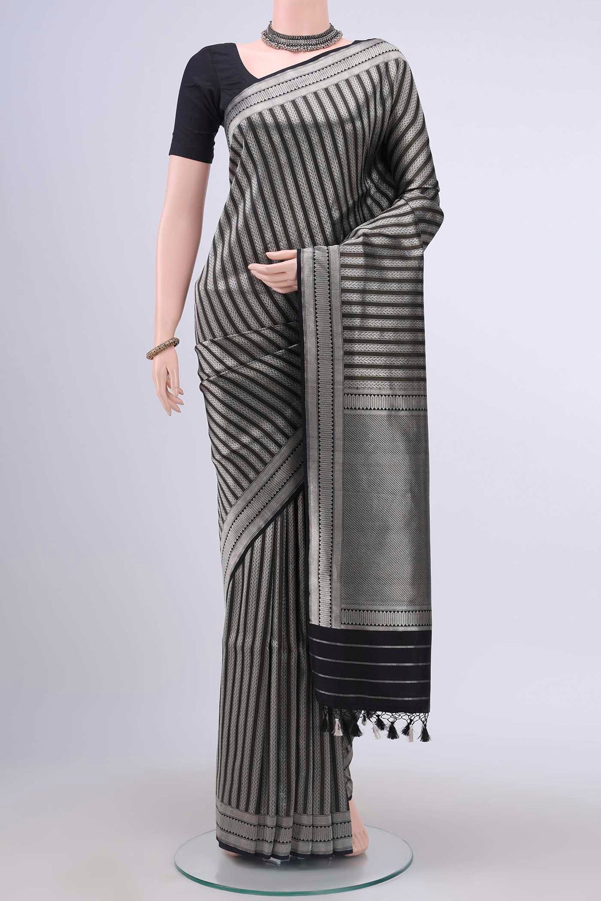 Black Dual Tone Banarasi Silk Saree with Stripes on the body and Zari Border displayed on a mannequin