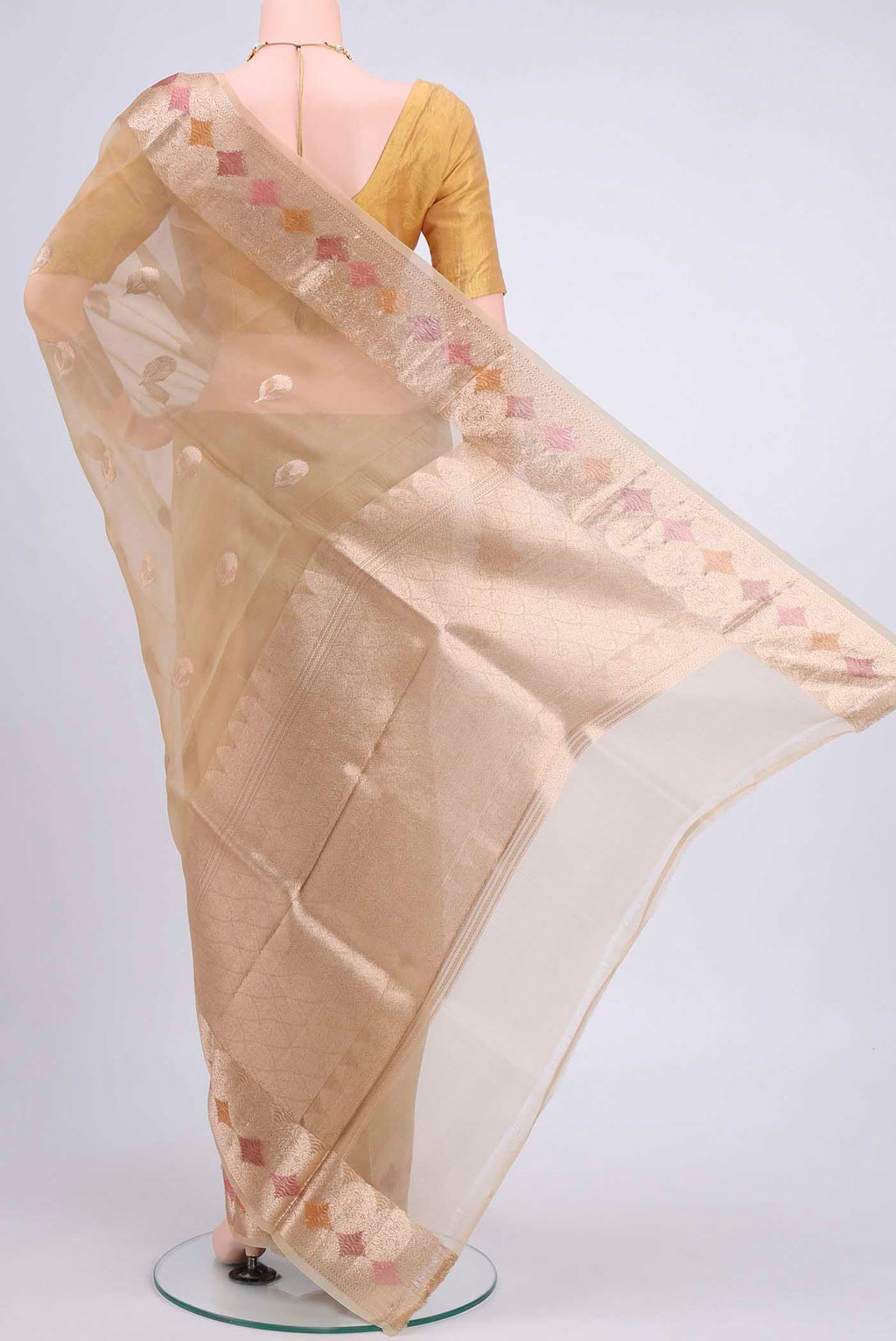 Flat view of Beige Organza Silk Saree with Zari Butta on the body and Zari Border