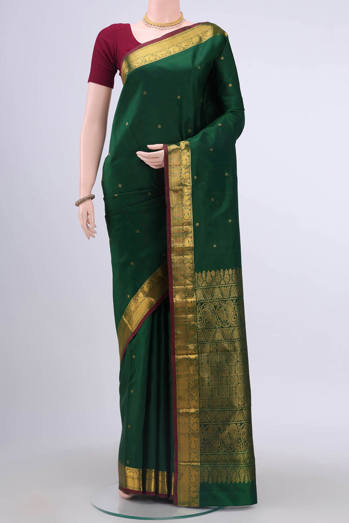 Bottle Green Kanchipuram Saree with Zari Butta on the body and Zari Border displayed on a mannequin